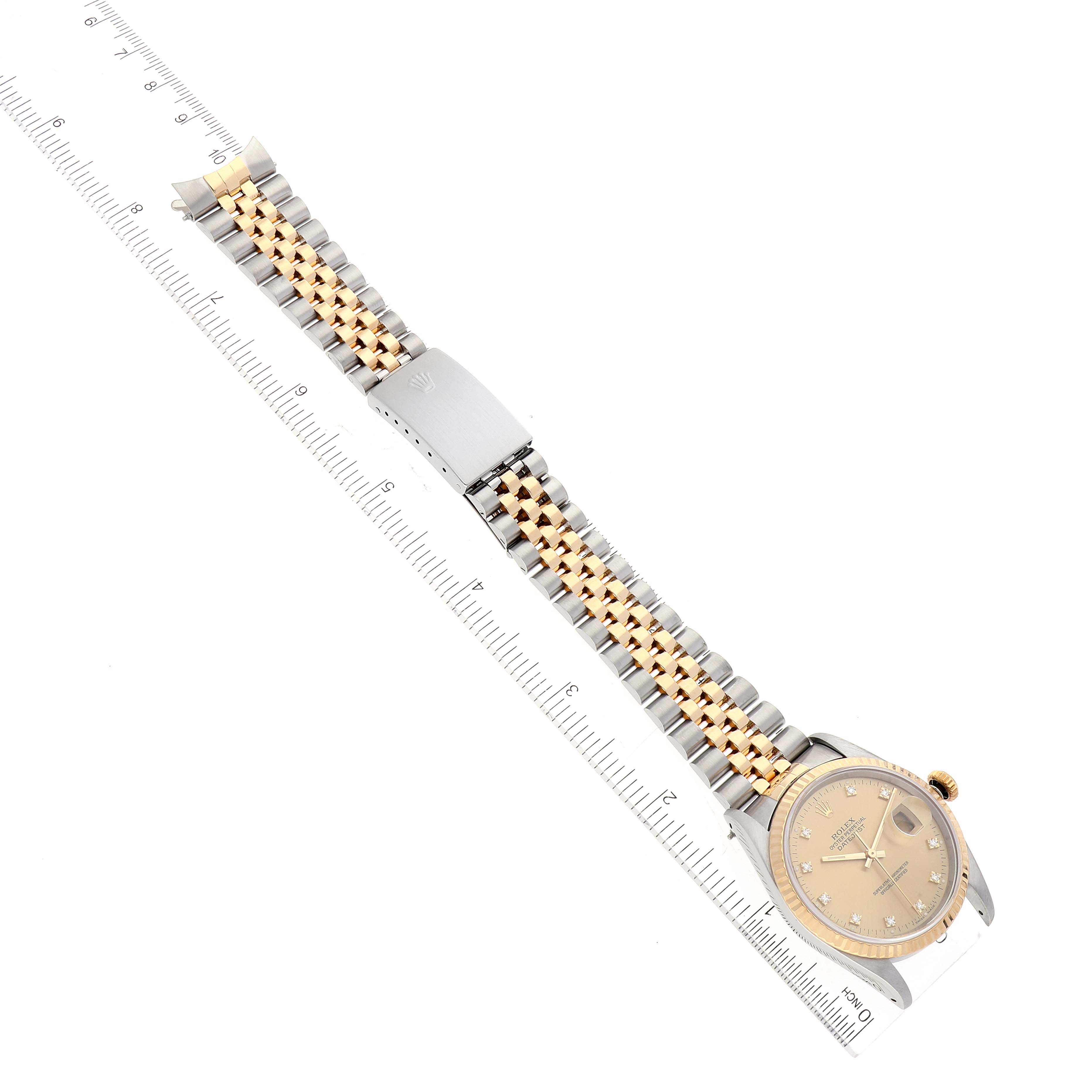 This image shows a Rolex Datejust 16233 Men's Steel and Gold (two tone) Champagne Dial 16233 Men's Steel and Gold (two tone) Champagne Dial watch laid flat with the face and two-tone bracelet visible, alongside a ruler for scale.
