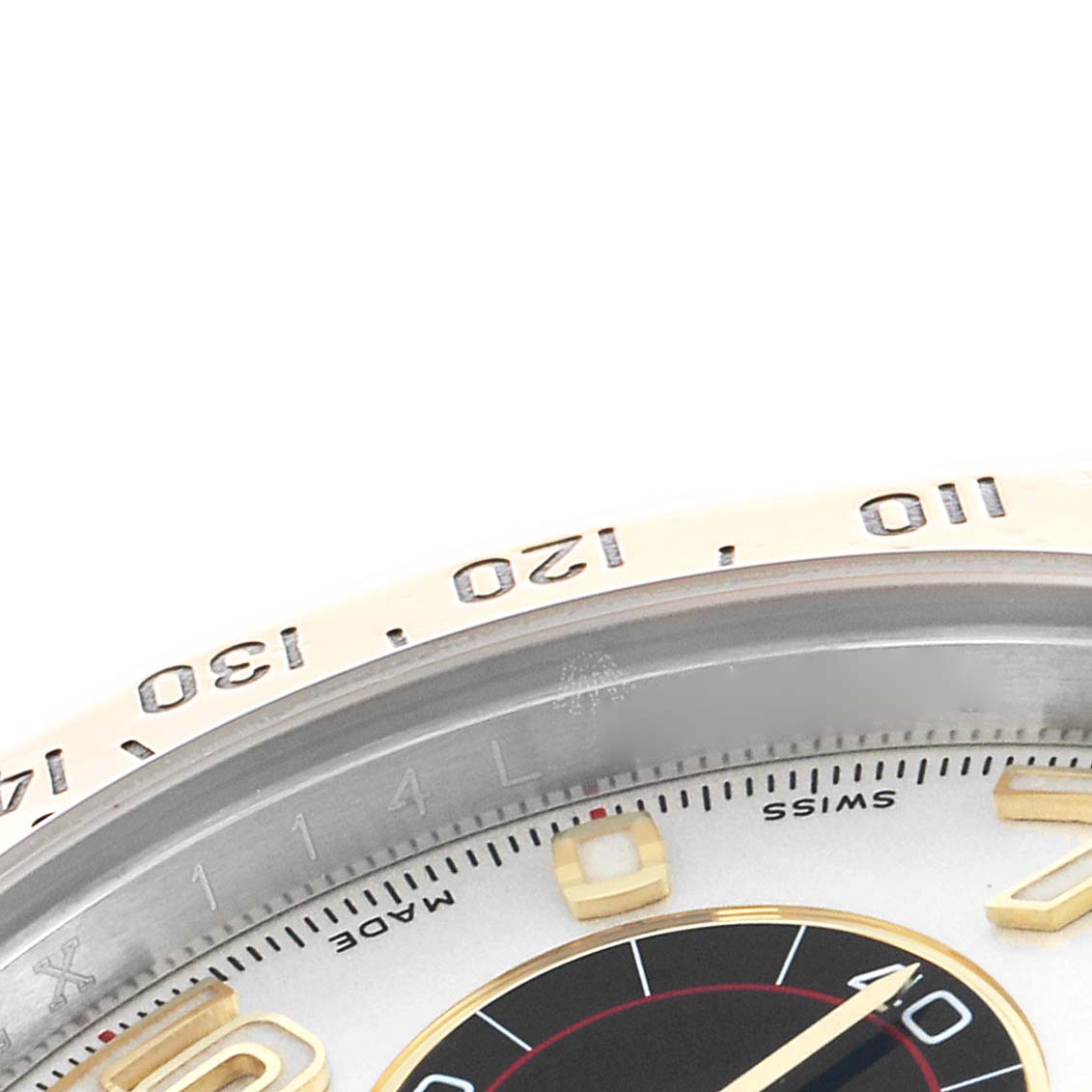 The image shows an angled close-up of the dial and bezel, highlighting the tachymetric scale and hour markers of the Rolex Daytona 116523 Men
s Steel and Gold (two tone) White Dial.