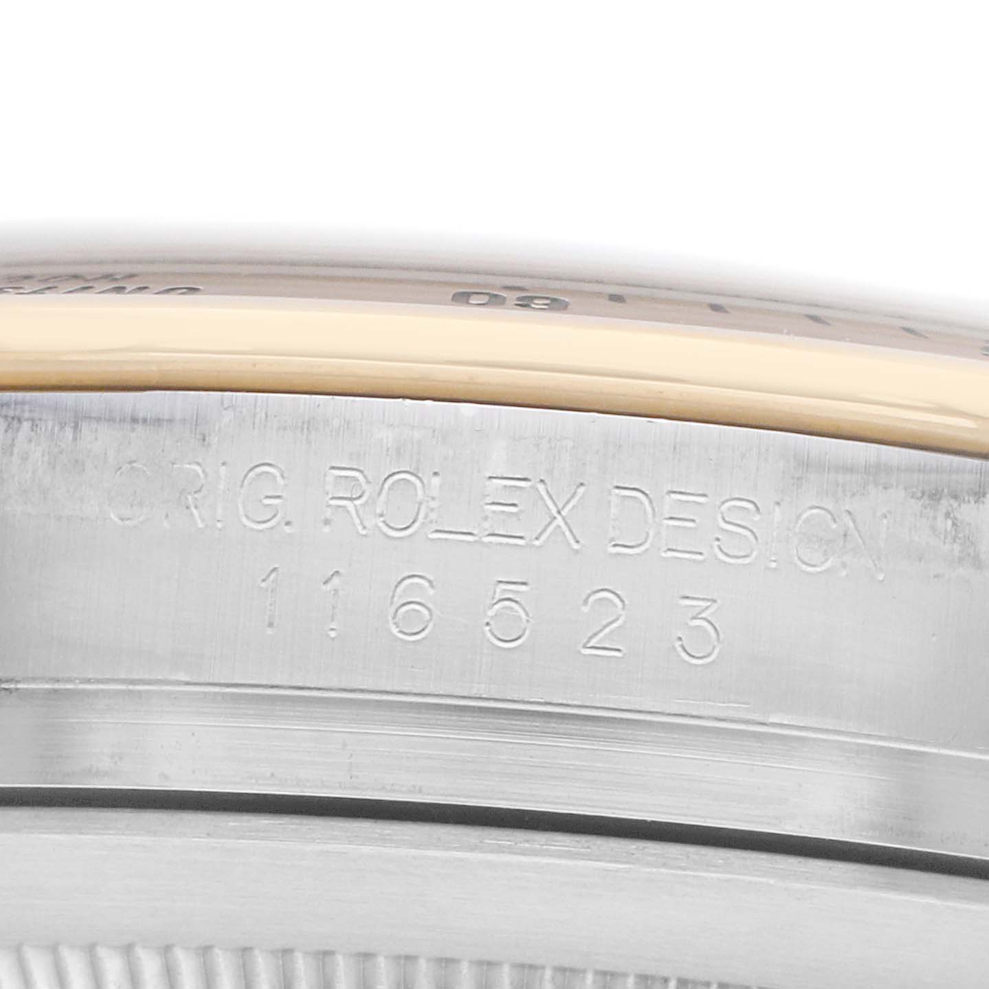 The image shows the side of a Rolex Daytona 116523 Men
s Steel and Gold (two tone) White Dial, focusing on the engraved model number and design details.
