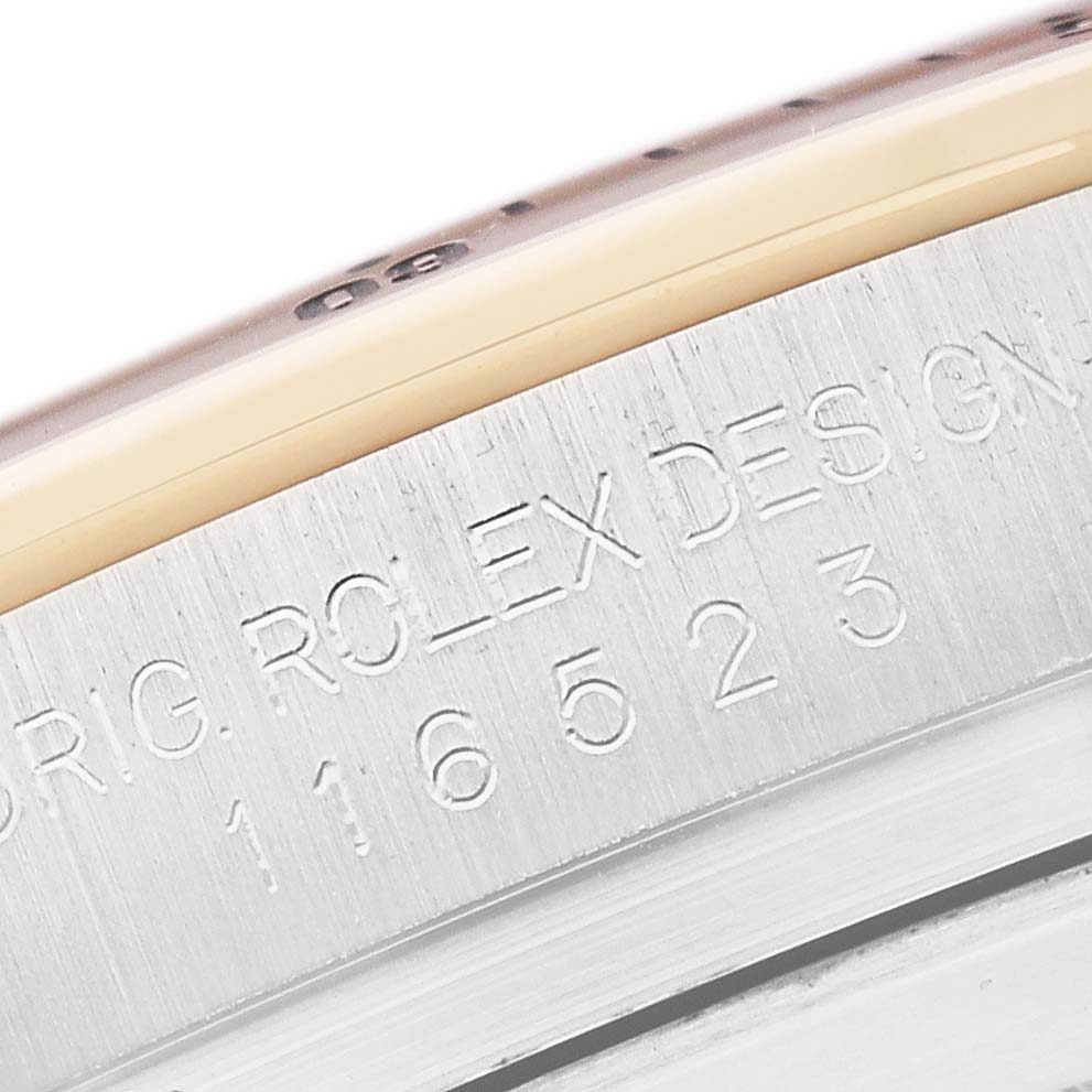 The image shows a close-up of the engraved side of a Rolex Daytona 116523 Men
s Steel and Gold (two tone) Mother of Pearl Dial watch case, displaying the model number.