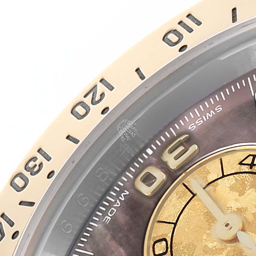 The image shows a close-up of the bezel and dial of a Rolex Daytona 116523 Men
s Steel and Gold (two tone) Mother of Pearl Dial, highlighting the minute markers and part of the subdial.