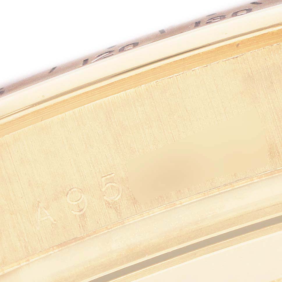 The image shows a close-up of the case side of a Rolex Daytona 16528 Men
s Yellow Gold Black Dial, focusing on metal engravings.