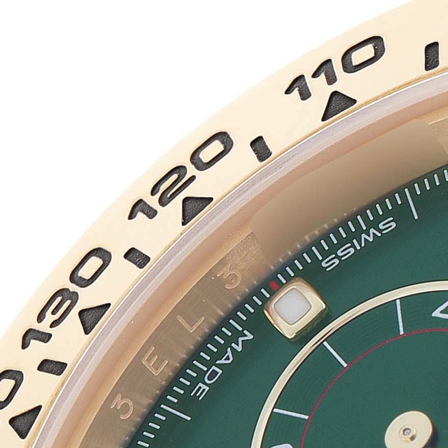 This image shows a close-up of the Rolex Daytona 116508 Men
s Yellow Gold Green Dial
s bezel and part of the dial, highlighting numerals and design details.