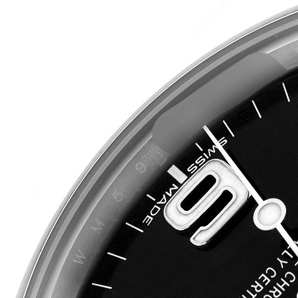The image shows a close-up of the dial and bezel of a Rolex Explorer 214270 Men
s Stainless Steel Black Dial watch, focusing on the "9" marker and surrounding text.