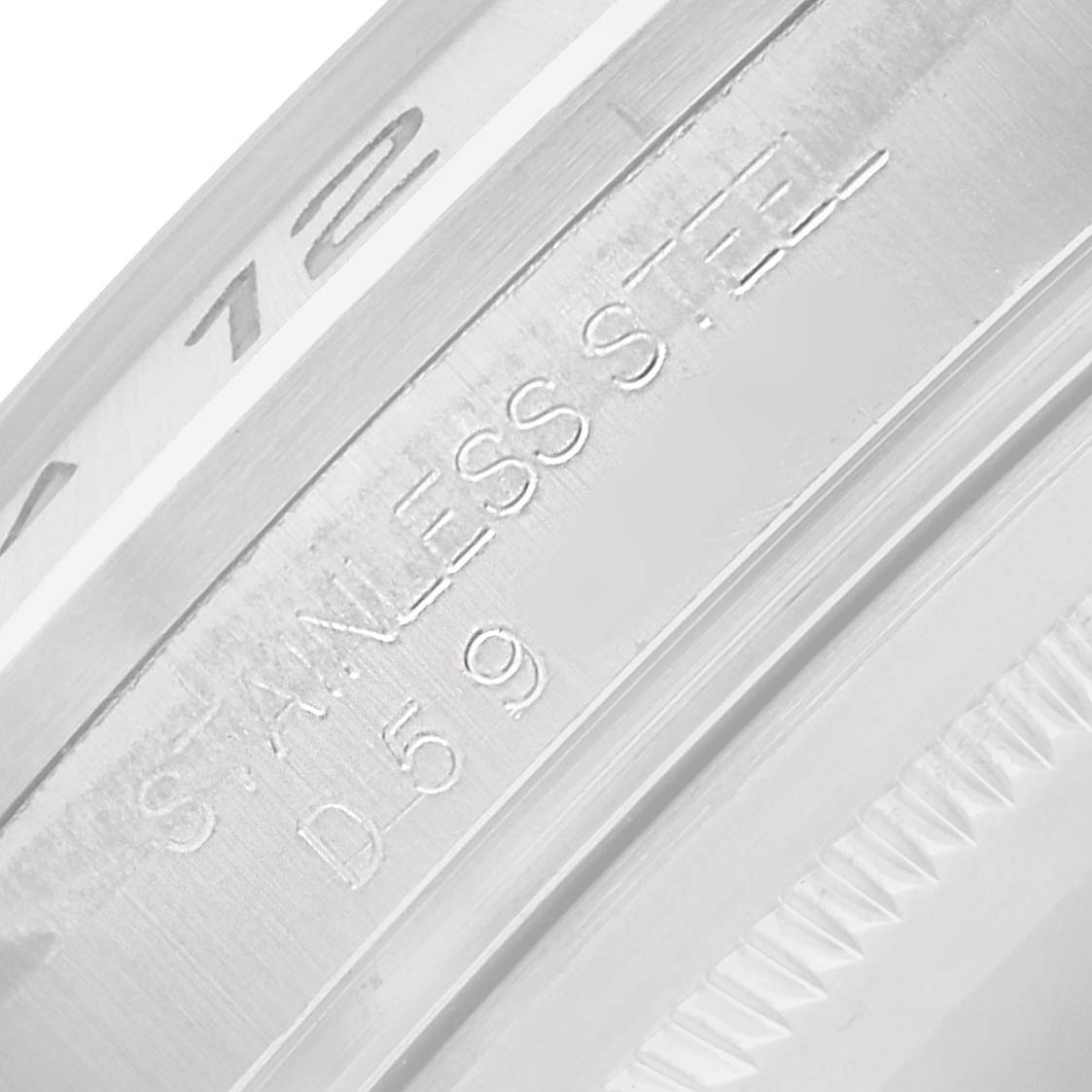 The image shows a detailed close-up of the Rolex Explorer 16570 Men
s Stainless Steel White Dial
s bezel and engraved text on its case.
