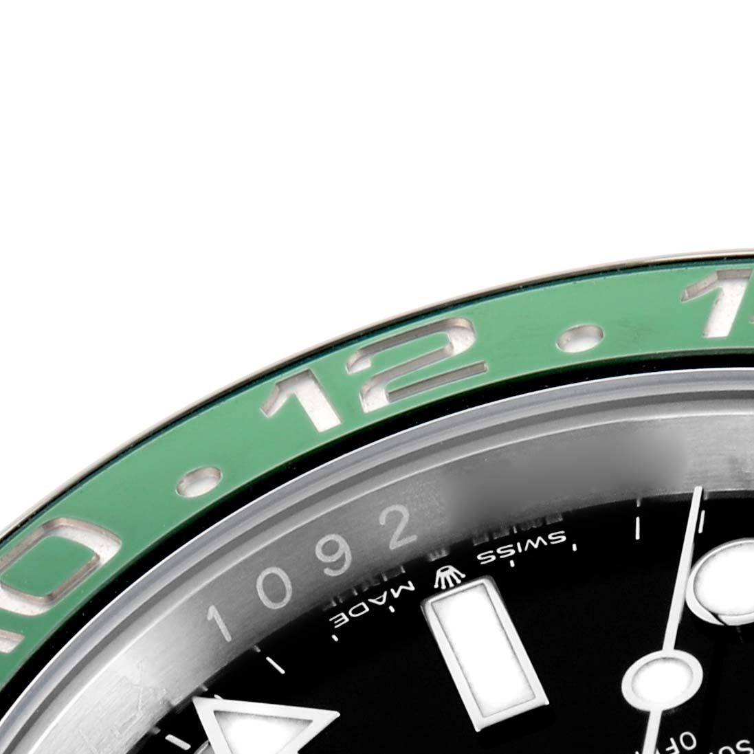 The image shows the upper-left portion of the Rolex GMT-Master 126720 Men
s Stainless Steel Black Dial
s green bezel and black dial with hour markers and part of the minute hand.