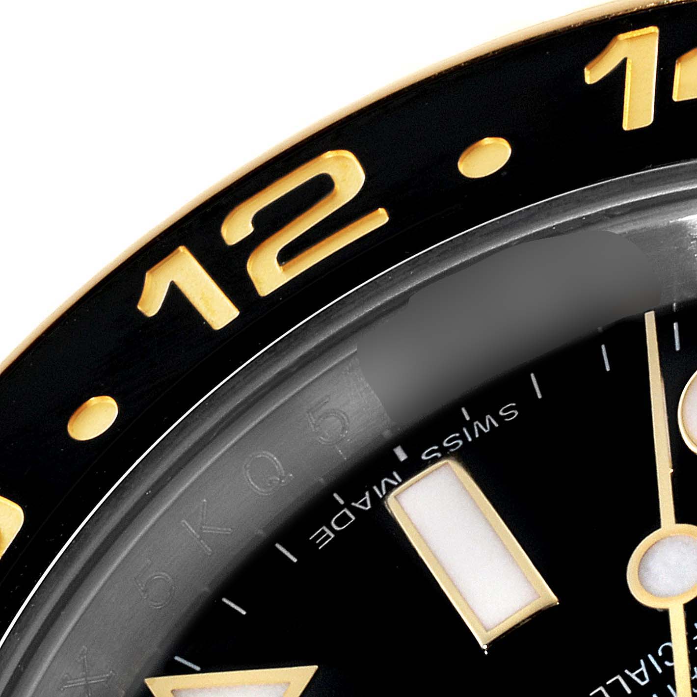 This close-up image of the Rolex GMT-Master 116713 Men's Steel and Gold (two tone) Black Dial 116713 Men's Steel and Gold (two tone) Black Dial watch shows part of the bezel, dial, and hour markers.