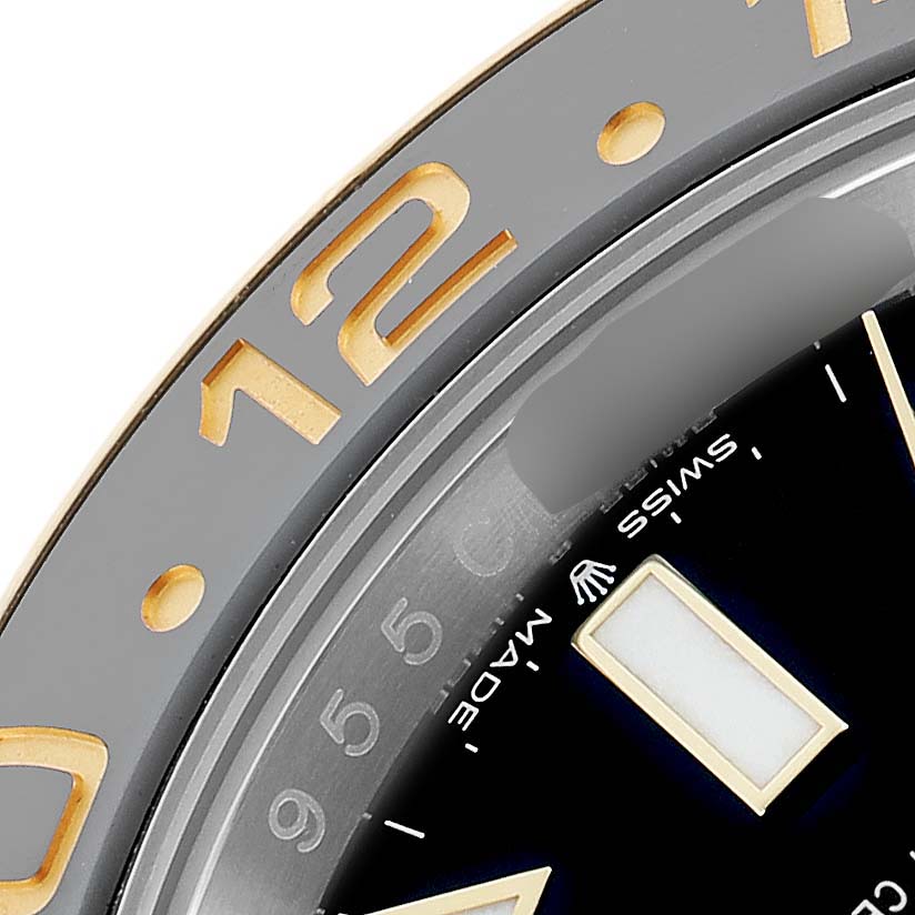 The close-up angle shows the bezel and dial edge of the Rolex GMT-Master 126713 Men
s Steel and Gold (two tone) Black Dial, highlighting the hour markers and "Swiss Made" text.
