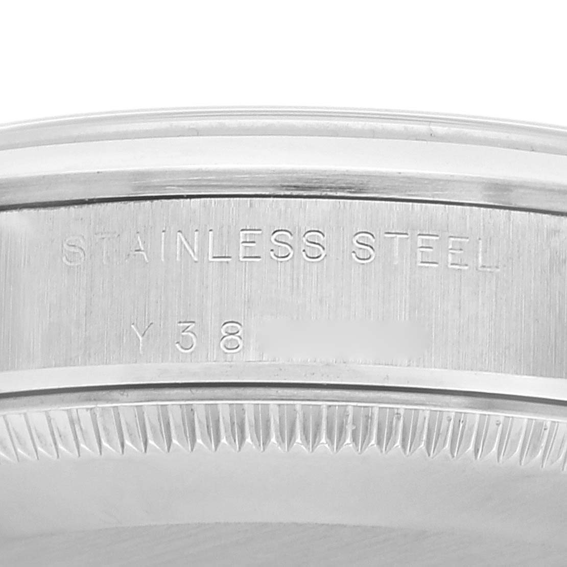 The image shows a close-up of the serial number and "Stainless Steel" engraving on the caseback edge of a Rolex Mid-Size 77080 Women
s Stainless Steel Silver Dial 77080 Women
s Stainless Steel Silver Dial model watch.