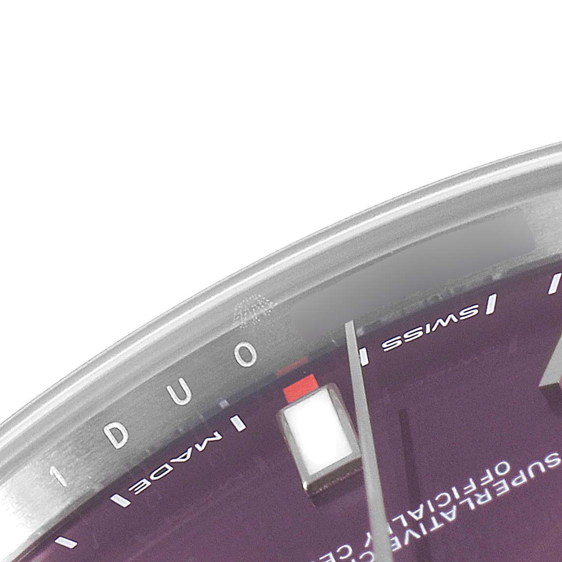 This close-up image shows the partial face, dial, and bezel of a Rolex Oyster Perpetual 114300 Men's Stainless Steel Burgundy Dial 114300 Men's Stainless Steel Burgundy Dial watch.