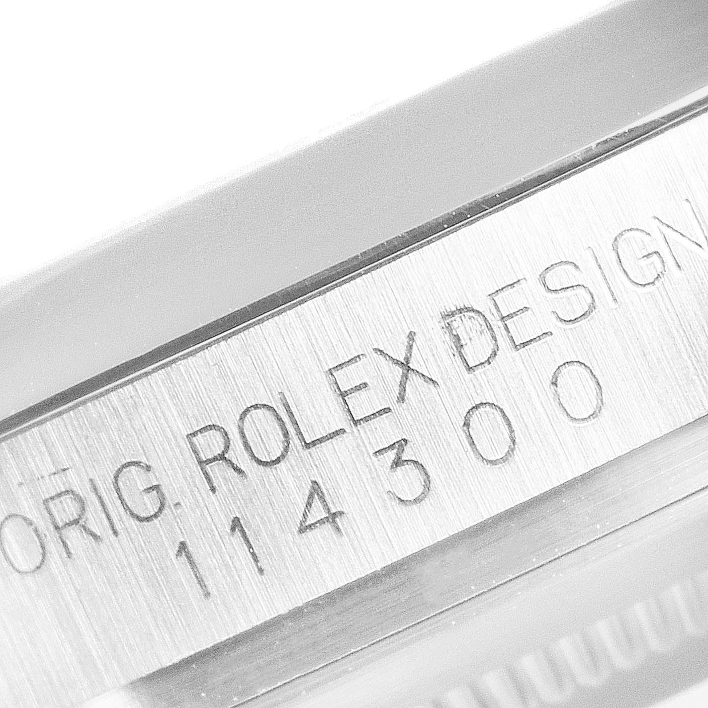 The image shows a close-up of the model number engravings on the side of a Rolex Oyster Perpetual 114300 Men's Stainless Steel Burgundy Dial 114300 Men's Stainless Steel Burgundy Dial watch.