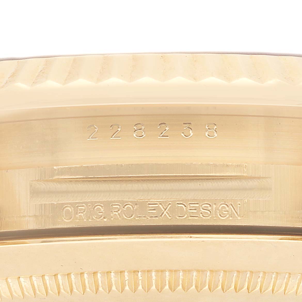 The image shows a close-up side view of the Rolex President 228238 Men
s Yellow Gold Black Dial model
s case, highlighting the engraved model number.