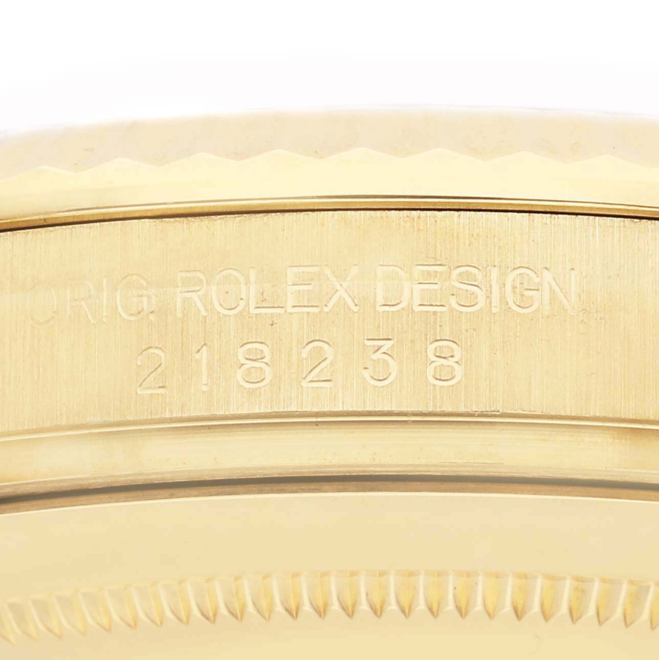 The image shows a close-up side angle of a Rolex President 218238 Men
s Yellow Gold Champagne Dial model, focusing on the engraved design and model number.