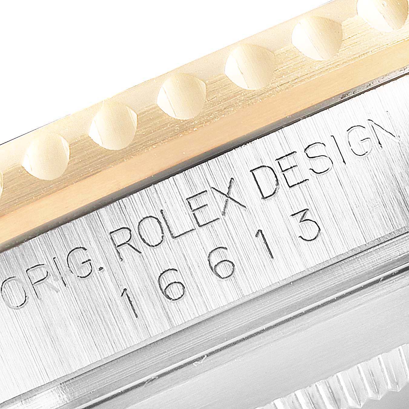 This close-up image shows the engraved reference number and original Rolex design marking on the case side of a Rolex Submariner 16613 Men's Steel and Gold (two tone) Blue Dial 16613 Men's Steel and Gold (two tone) Blue Dial.