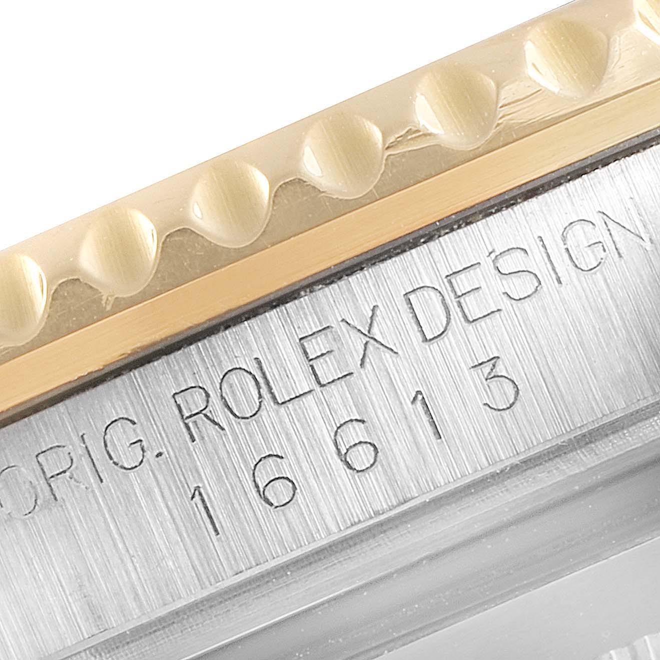 This close-up image of a Rolex Submariner 16613 Men's Steel and Gold (two tone) Blue Dial 16613 Men's Steel and Gold (two tone) Blue Dial watch shows part of the bezel and the case, including the engraved model number 16613.