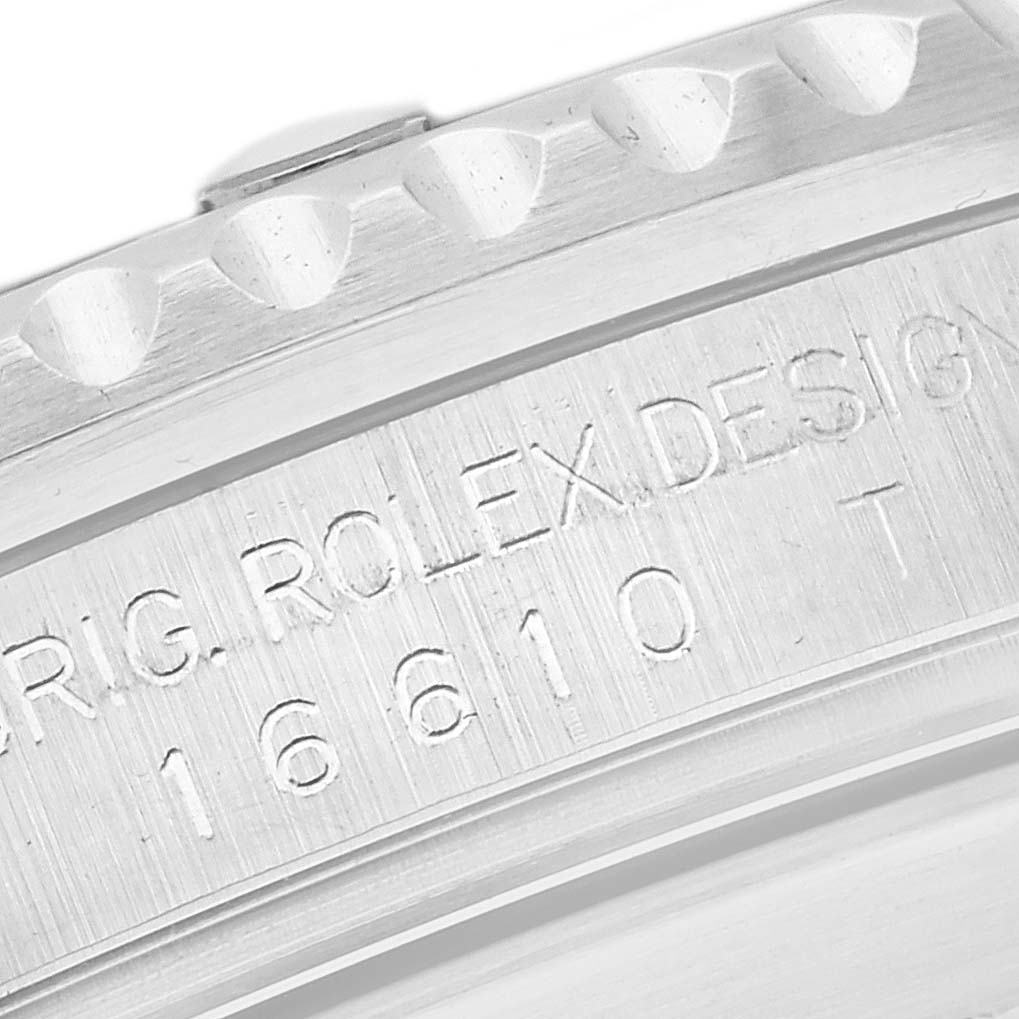 This close-up image shows the engraved serial number and part of the bezel on a Rolex Submariner 16610 Men's Stainless Steel Black Dial 16610 Men's Stainless Steel Black Dial watch.