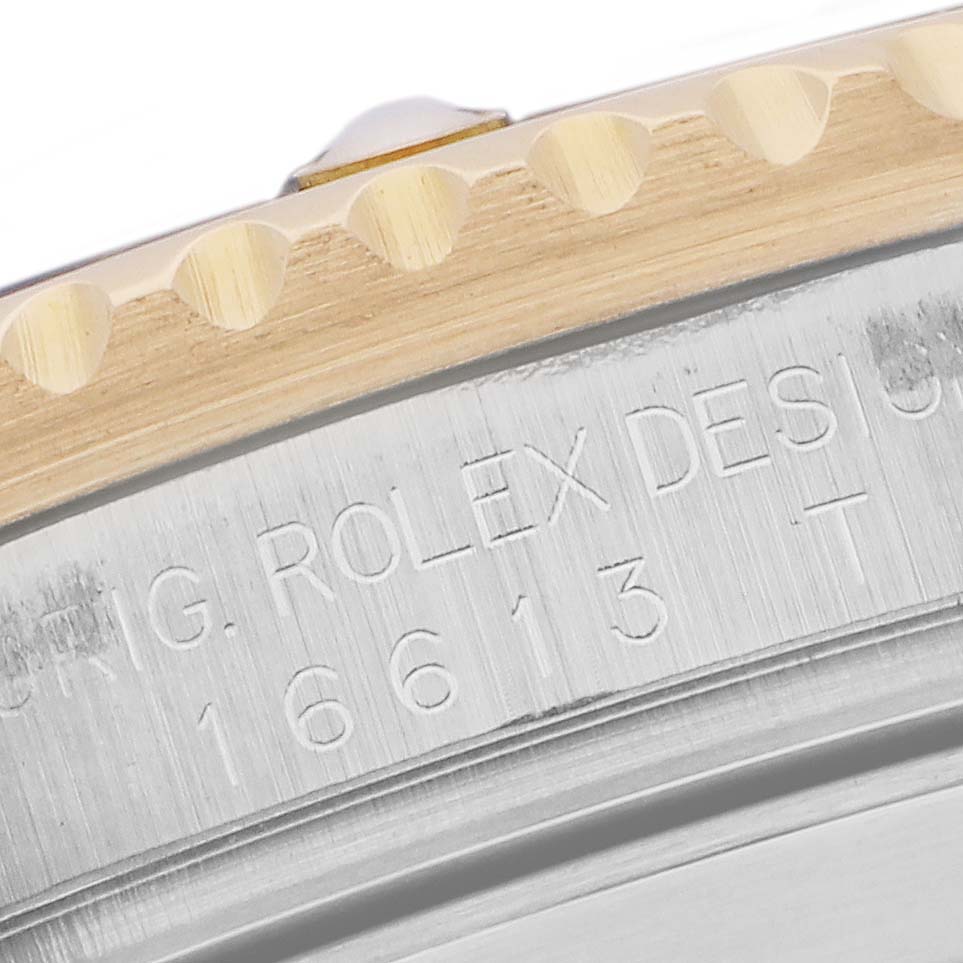 The image shows a close-up of the engraved side of a Rolex Submariner 16613 Men
s Steel and Gold (two tone) Blue Dial, highlighting the model number and part of the bezel.