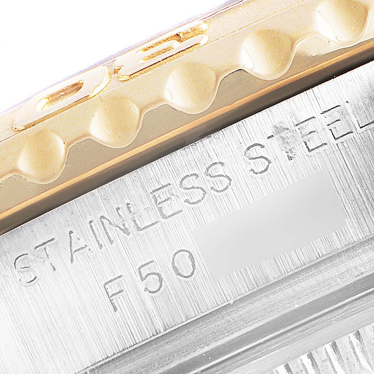 Close-up of the side of a Rolex Yacht-Master 169623 Women's Steel and Gold (two tone) White Dial 169623 Women's Steel and Gold (two tone) White Dial showing its stainless steel and gold bezel with part of the inscription.