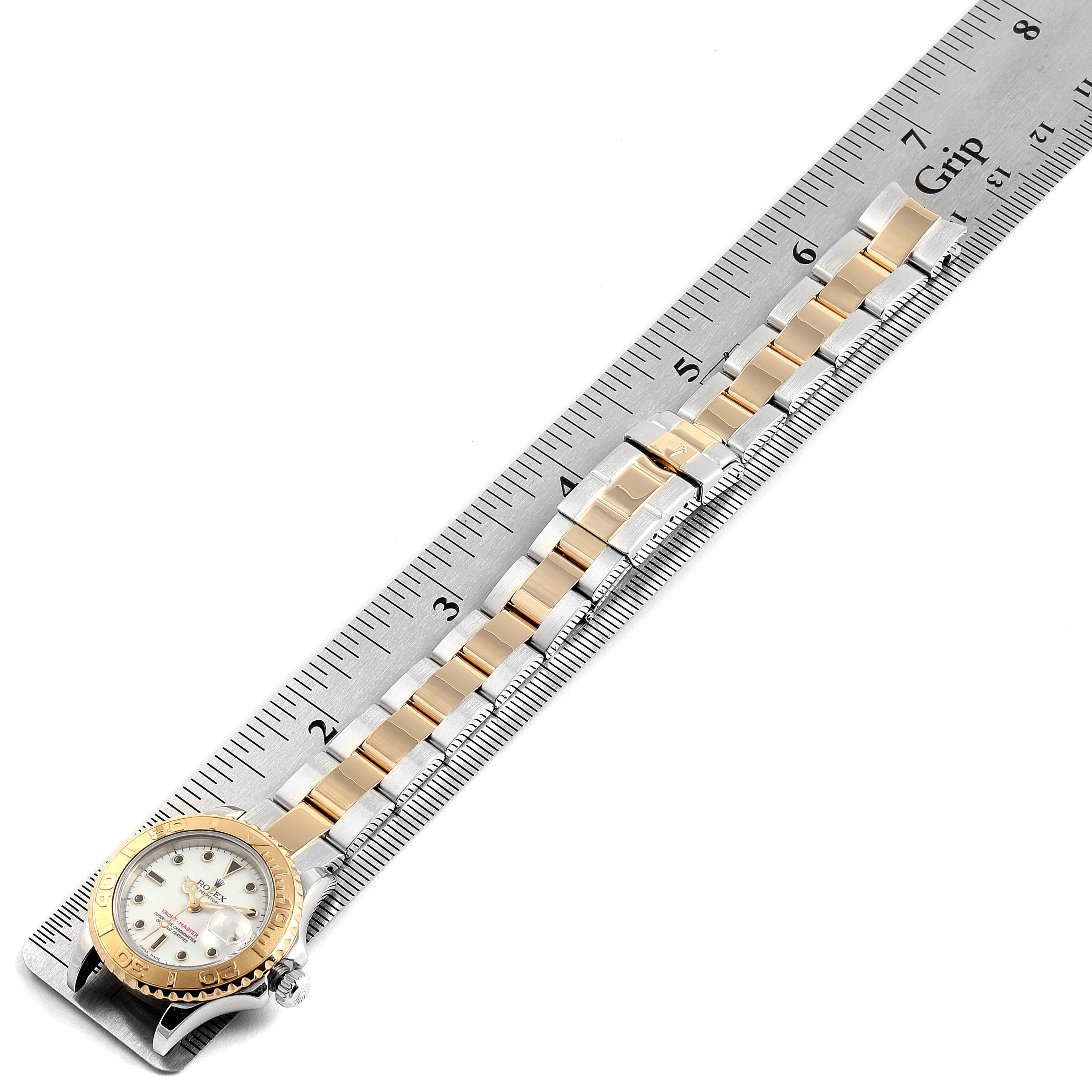The image shows a Rolex Yacht-Master 169623 Women's Steel and Gold (two tone) White Dial 169623 Women's Steel and Gold (two tone) White Dial watch at an overhead angle, displaying the full length of the watch and its metal bracelet placed on a ruler.