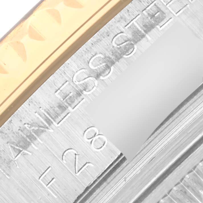 This close-up image of a Rolex Yacht-Master 168623 Men's Steel and Gold (two tone) Grey Dial 168623 Men's Steel and Gold (two tone) Grey Dial watch shows part of the serial number engraving and the stainless steel case edge.