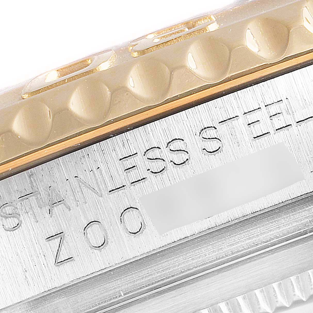 This image shows a close-up of the bezel and part of the engraved stainless steel case of a Rolex Yacht-Master 16623 Men
s Steel and Gold (two tone) Champagne Dial 16623 Men
s Steel and Gold (two tone) Champagne Dial watch.