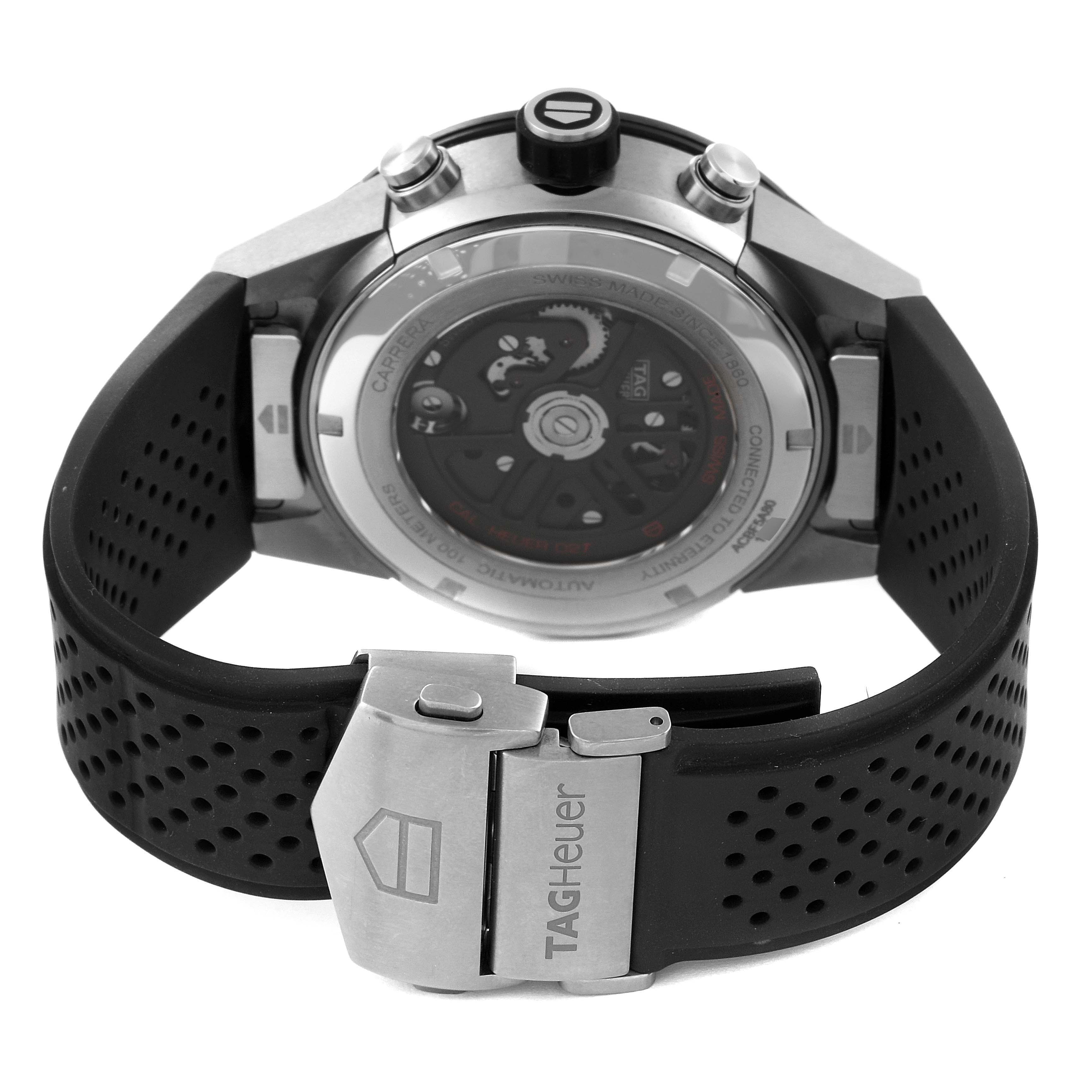 The image shows the back of a Tag Heuer Carrera ACBF5A80 Men's Titanium Black Dial ACBF5A80 Men's Titanium Black Dial watch, highlighting its automatic movement and black perforated strap with a clasp.