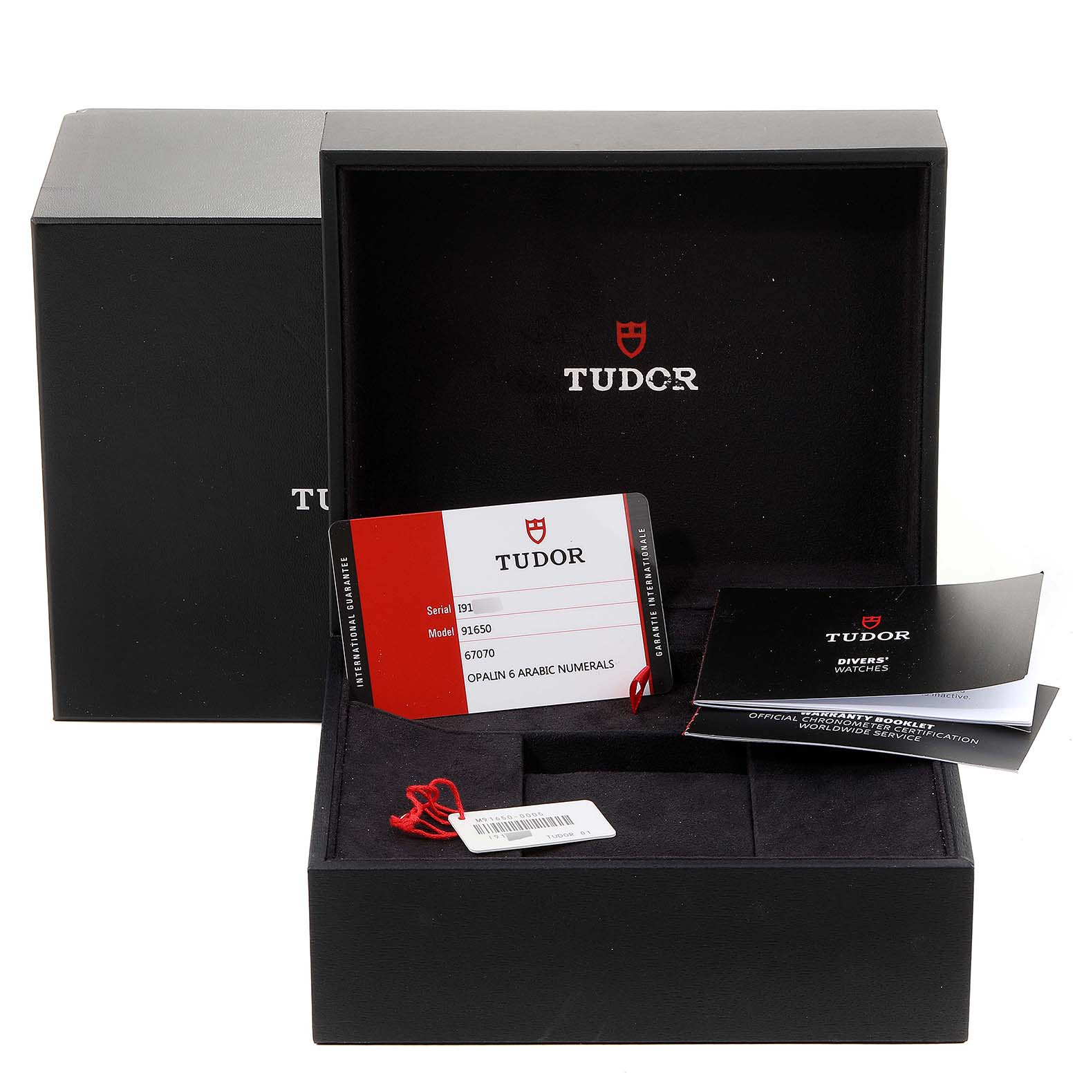 The image shows the packaging, warranty card, and booklets for a Tudor 1926 M91650-0005 Men's Stainless Steel Silver Dial M91650-0005 Men's Stainless Steel Silver Dial model watch.