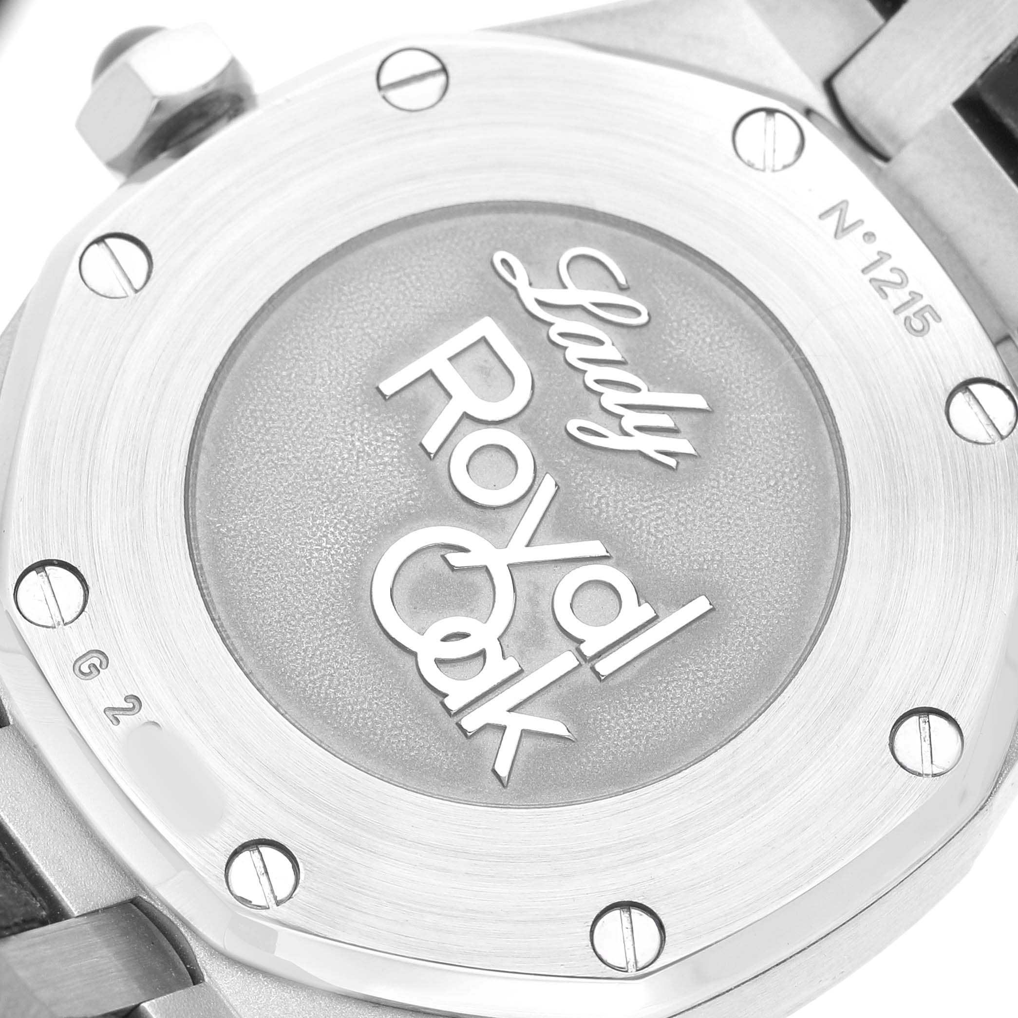 The image shows the back of an Audemars Piguet Royal Oak 77321ST.ZZ.D002CR.01 Women's Stainless Steel Black Dial watch, featuring its engraved text and screws.