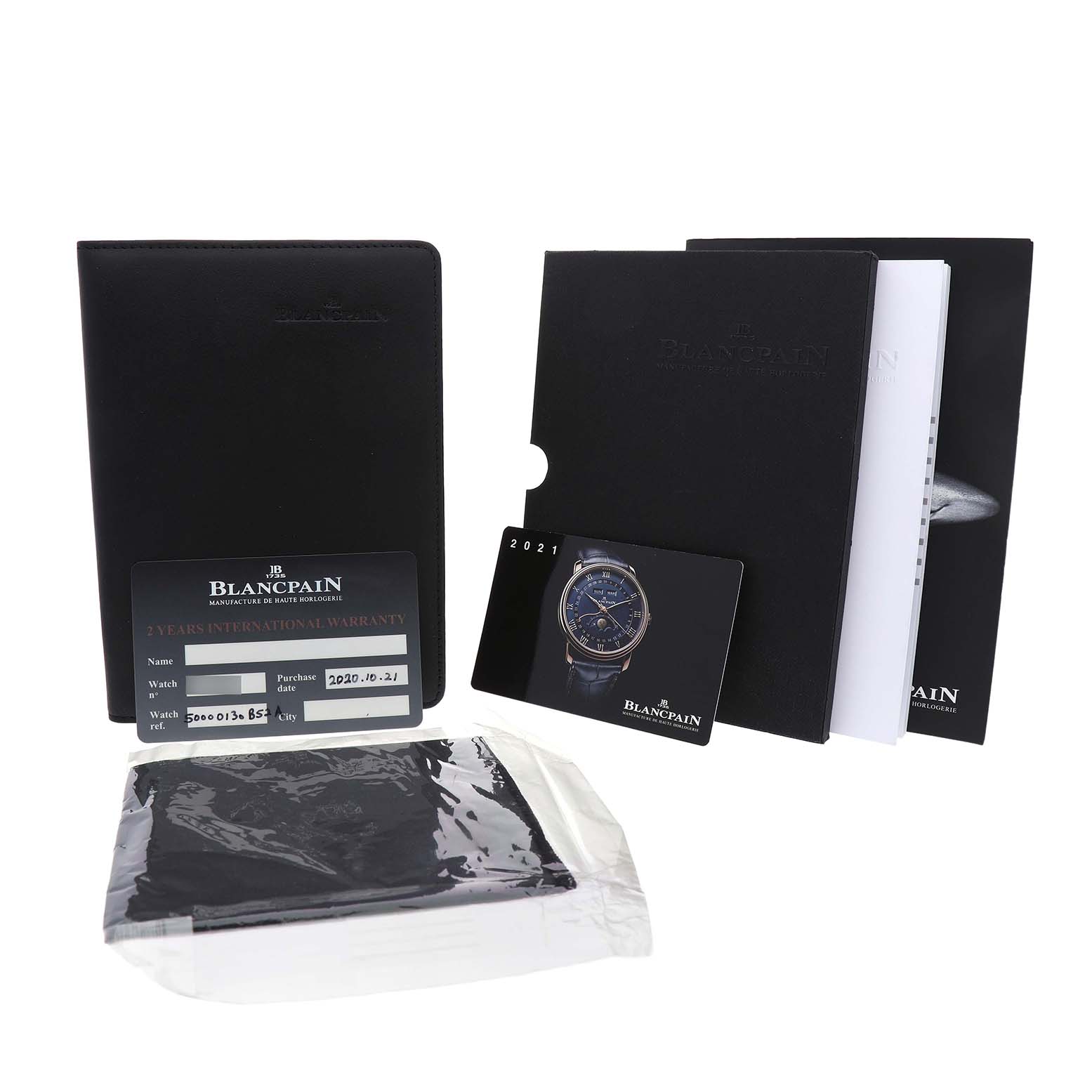 The image shows accessories for the Blancpain Fifty Fathoms 5000-0130-B52A Men's Stainless Steel Black Dial, including booklets, a warranty card, and a packaged cloth.