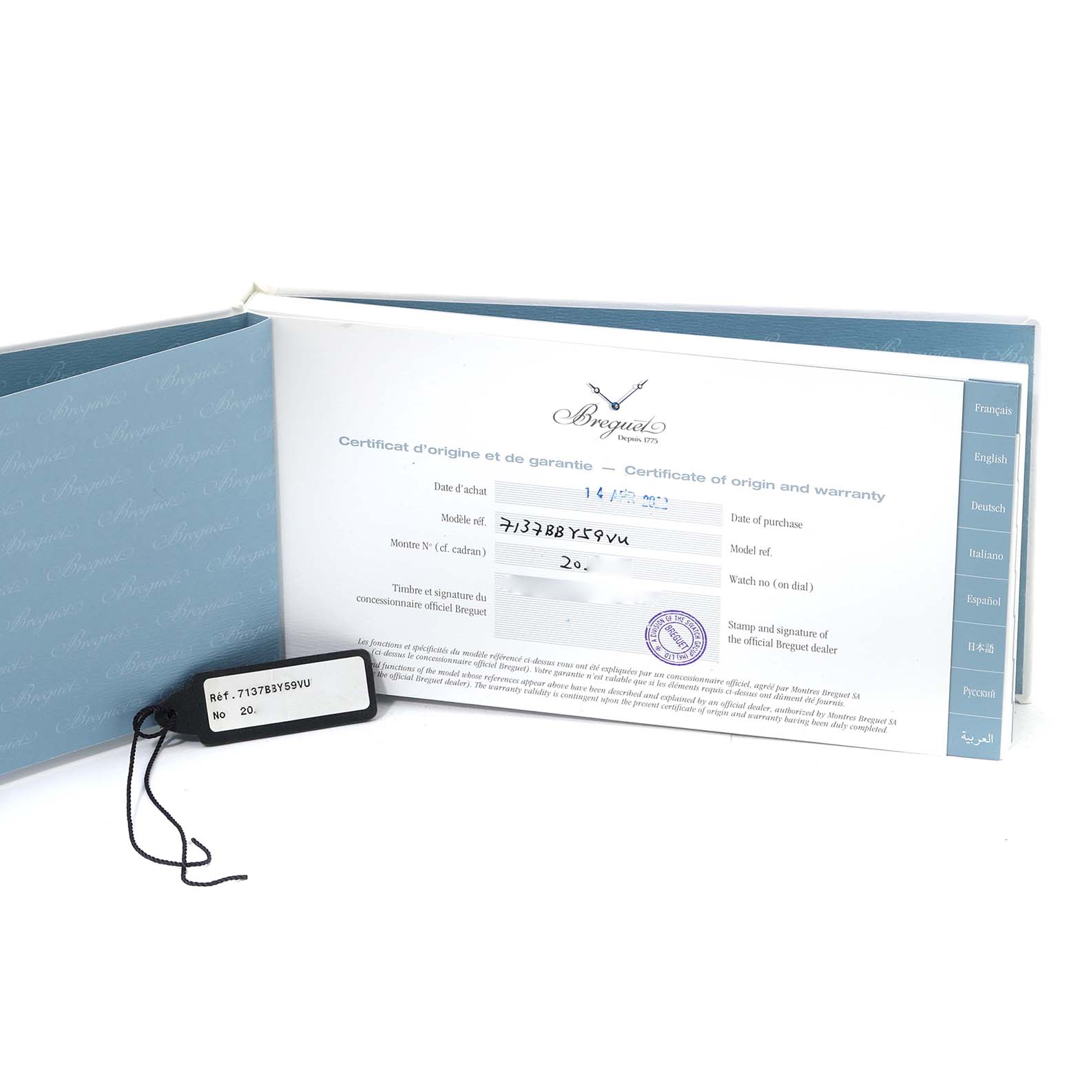 The image shows the warranty certificate and a tag for the Breguet Classique 7137BB/Y5/9VU Men's White Gold Blue Dial 7137BB/Y5/9VU Men's White Gold Blue Dial model watch, captured from a front angle.