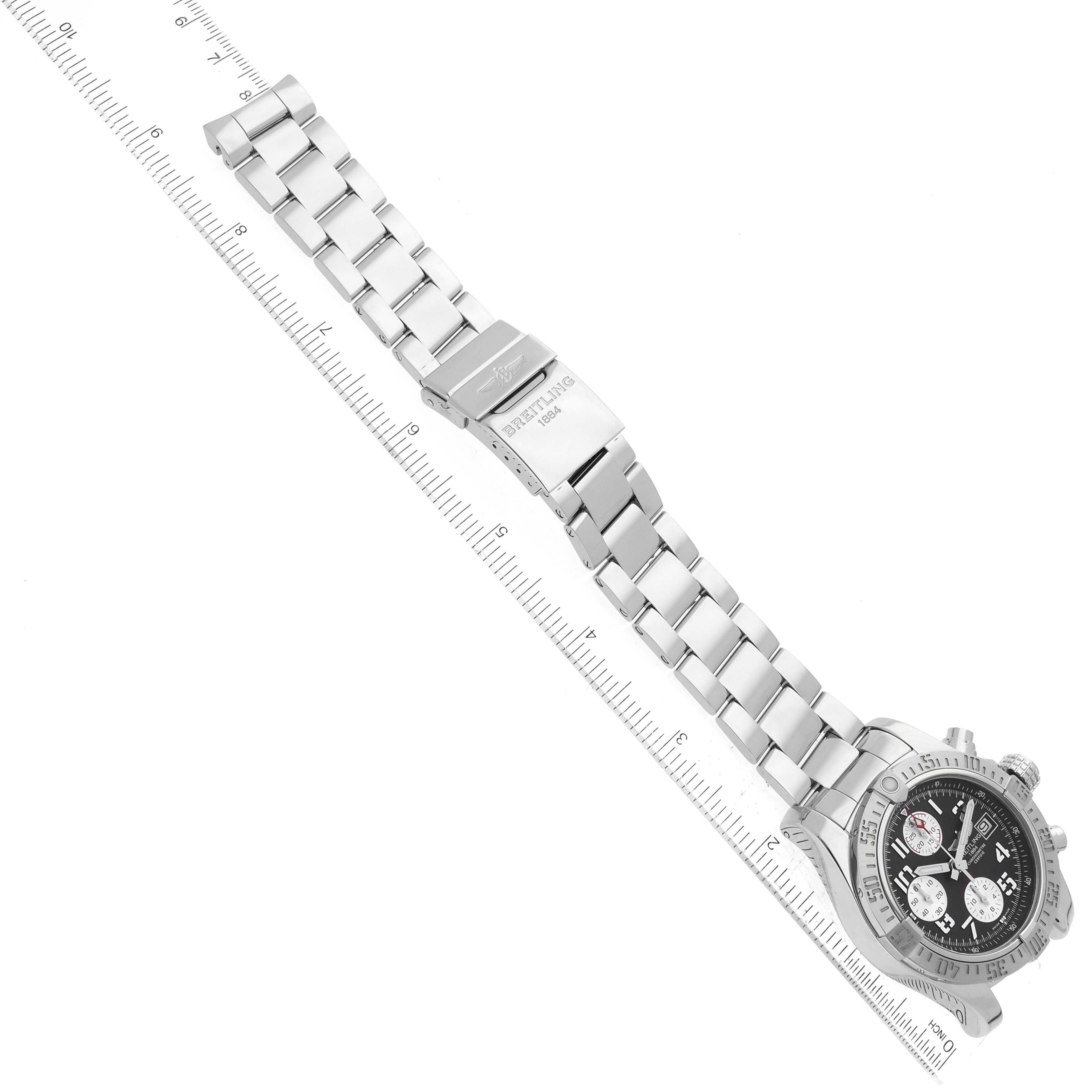 The image shows the Breitling Avenger A13381 Men's Stainless Steel Grey Dial A13381 Men's Stainless Steel Grey Dial watch from an overhead angle, highlighting its metal bracelet and clasp alongside a ruler for scale.