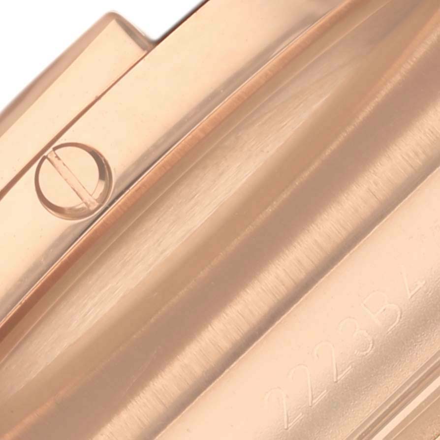 This image shows a close-up of the bezel and case side of the Breitling Chronomat RB0136E31Q1S1 Men's Rose Gold Brown Dial RB0136E31Q1S1 Men's Rose Gold Brown Dial watch model, including a screw and partial engraving.