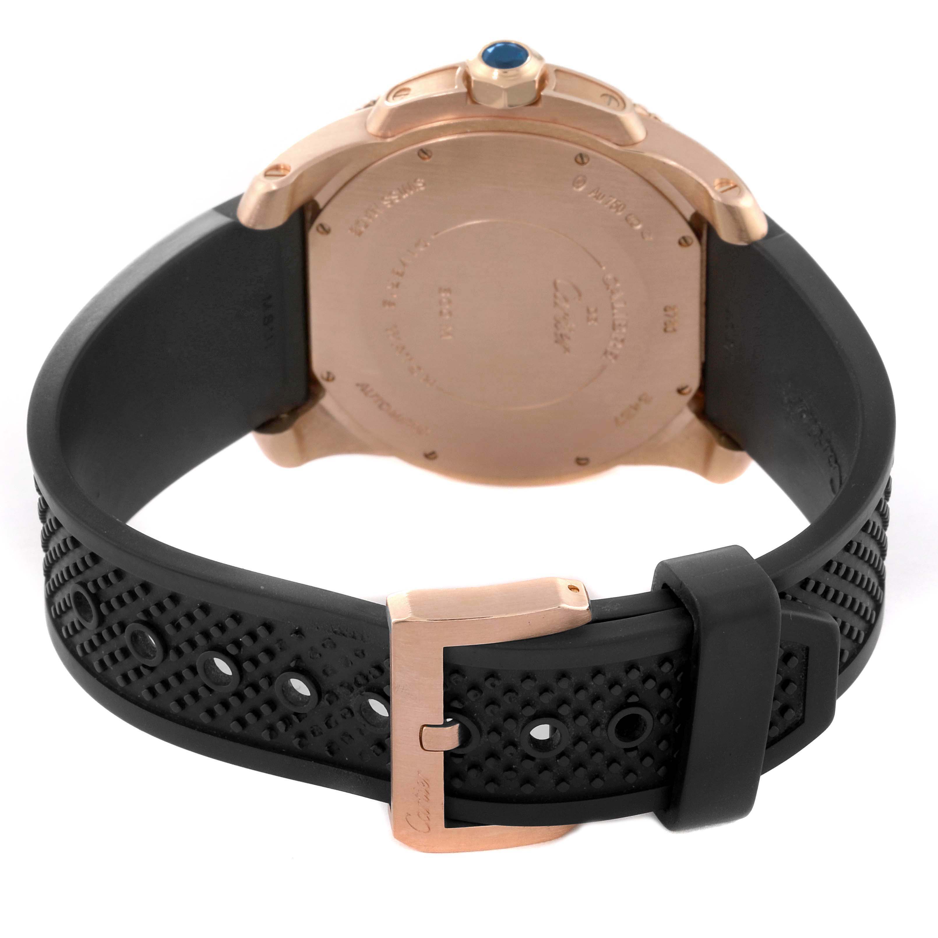 The image shows the back of a Calibre de Cartier watch by Cartier, highlighting its rose gold case, black rubber strap, and clasp.