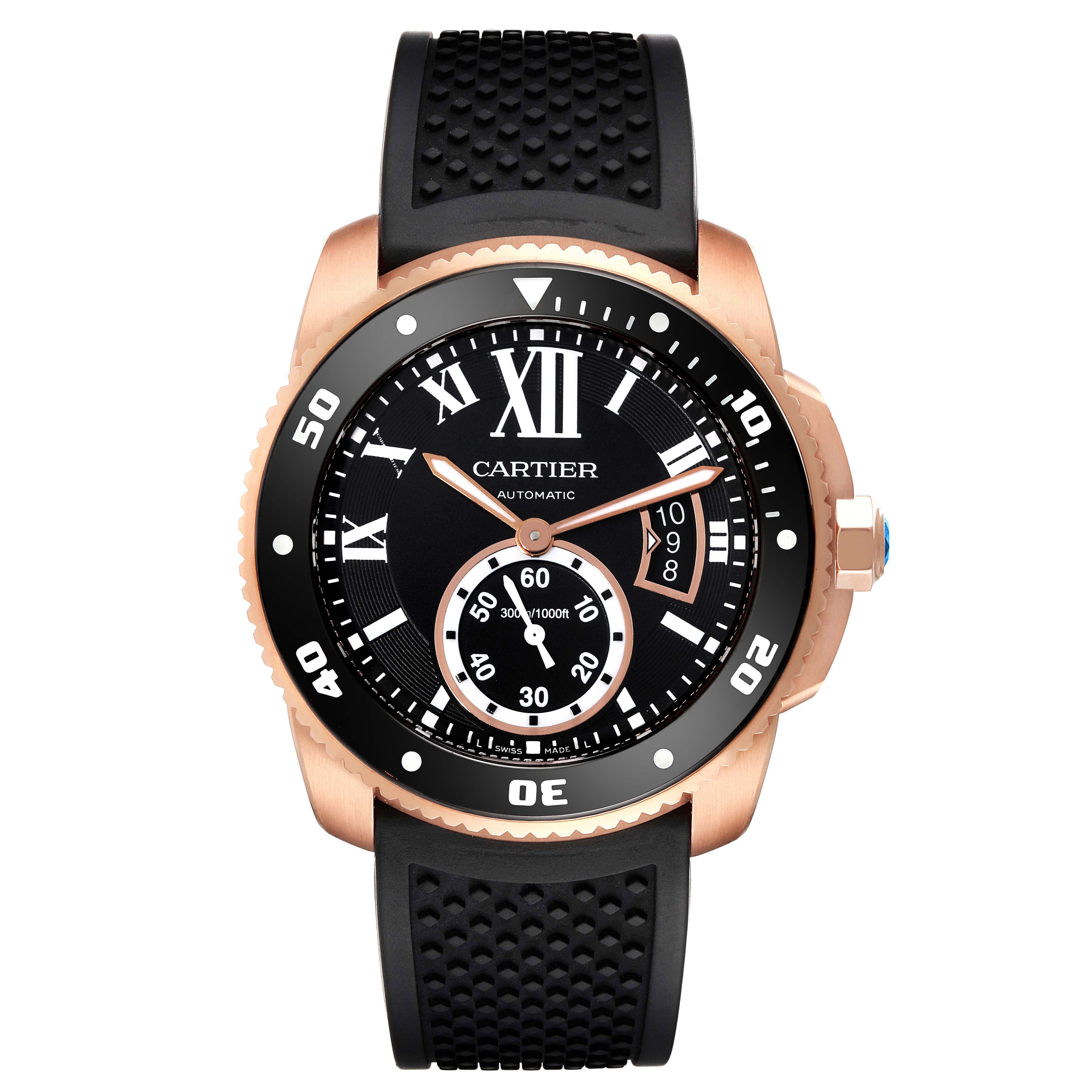 The image shows a front view of the Calibre de Cartier watch by Cartier, highlighting the black dial, rose gold case, and black rubber strap.