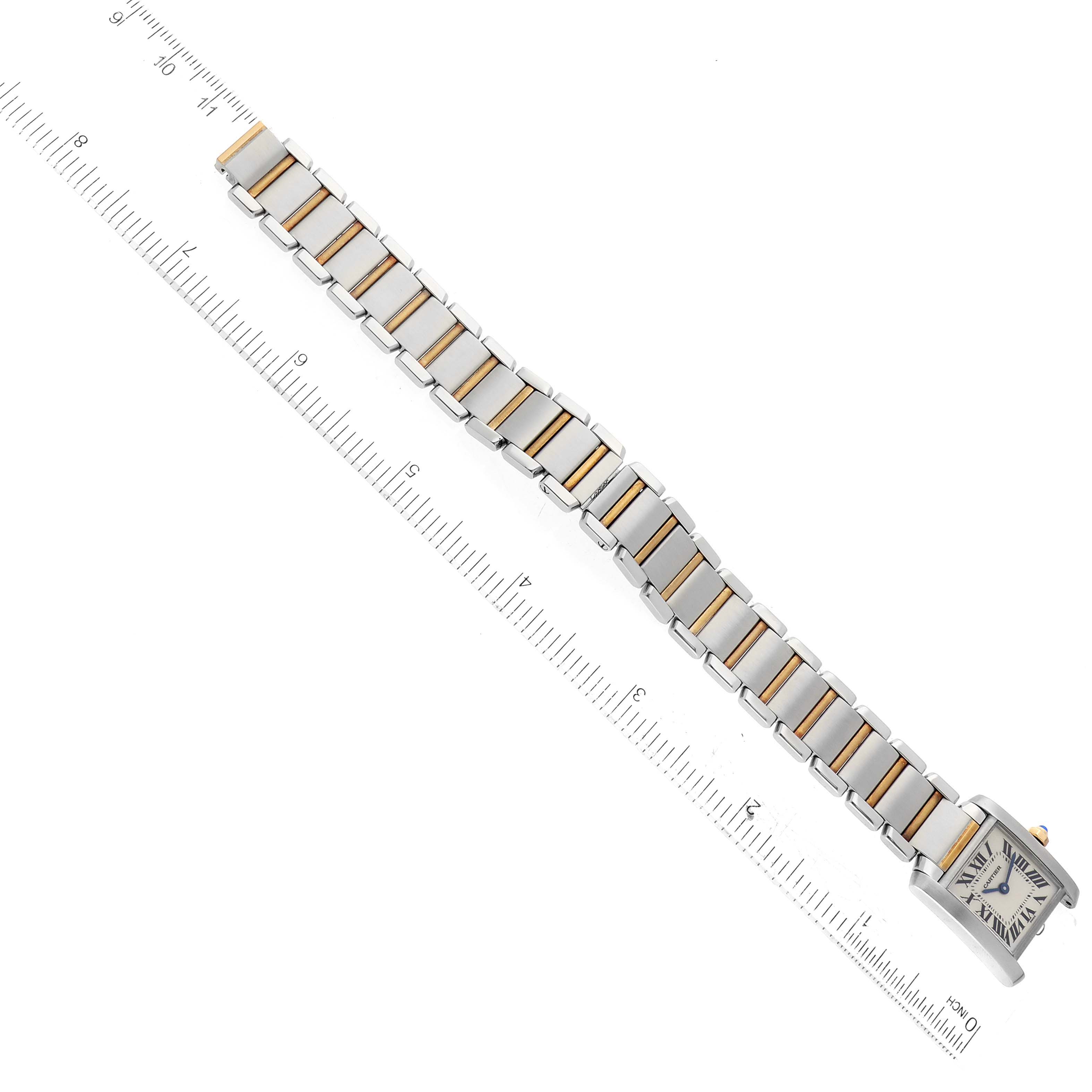The image shows the Tank Francaise model by Cartier from a top-down angle, highlighting its face and bracelet against a ruler.