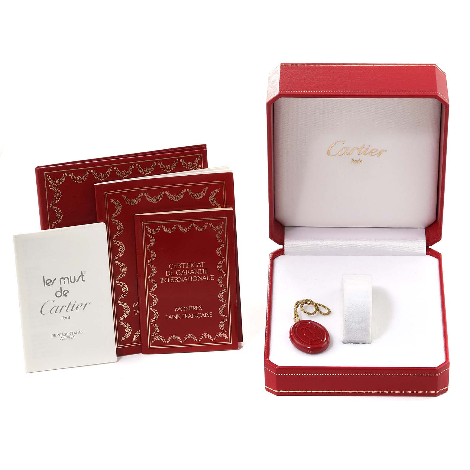 The image shows the packaging and documentation for a Cartier Tank Française model, including an open red box and warranty booklets.
