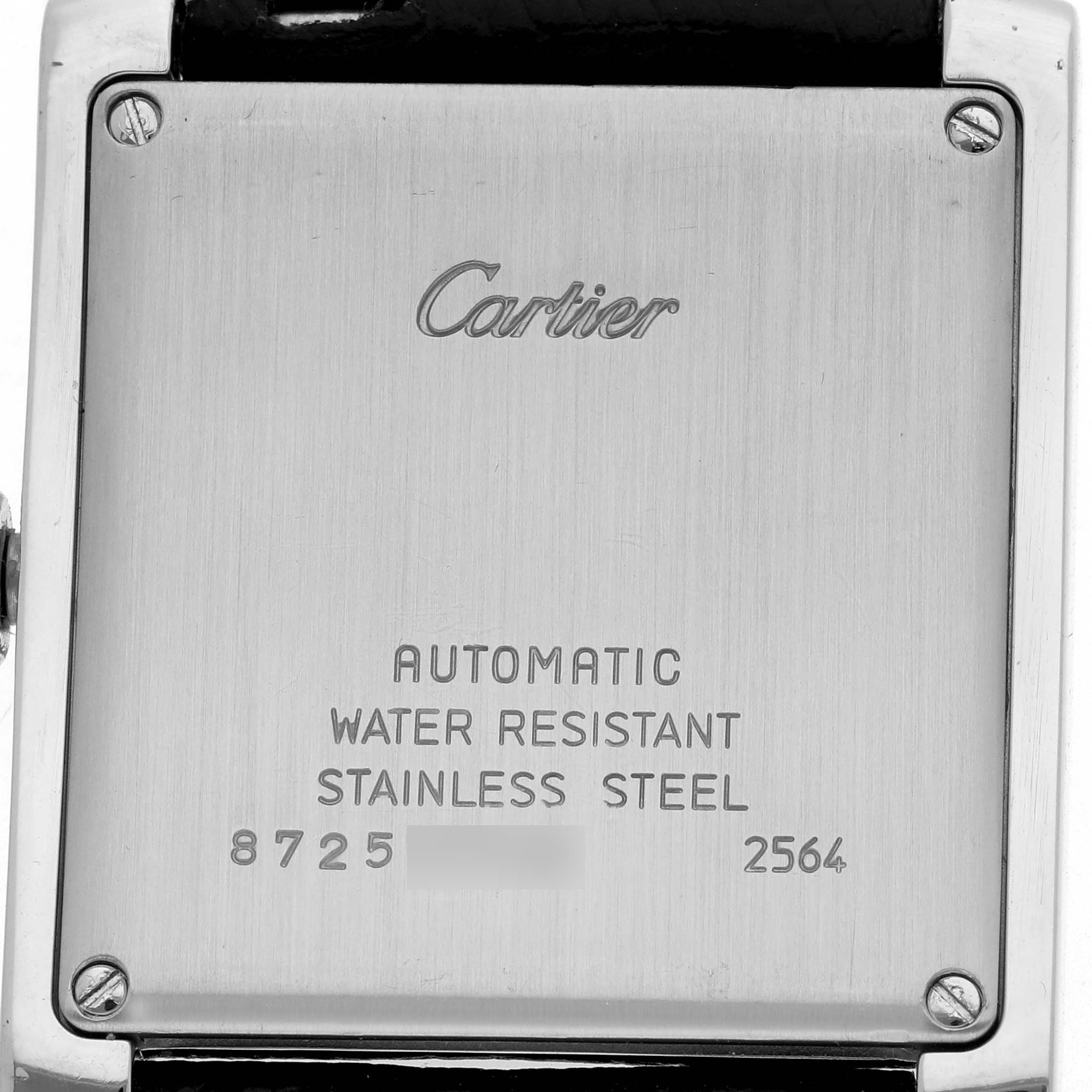 The image shows the backplate of a Cartier Tank Française with engraved details and visible screws.