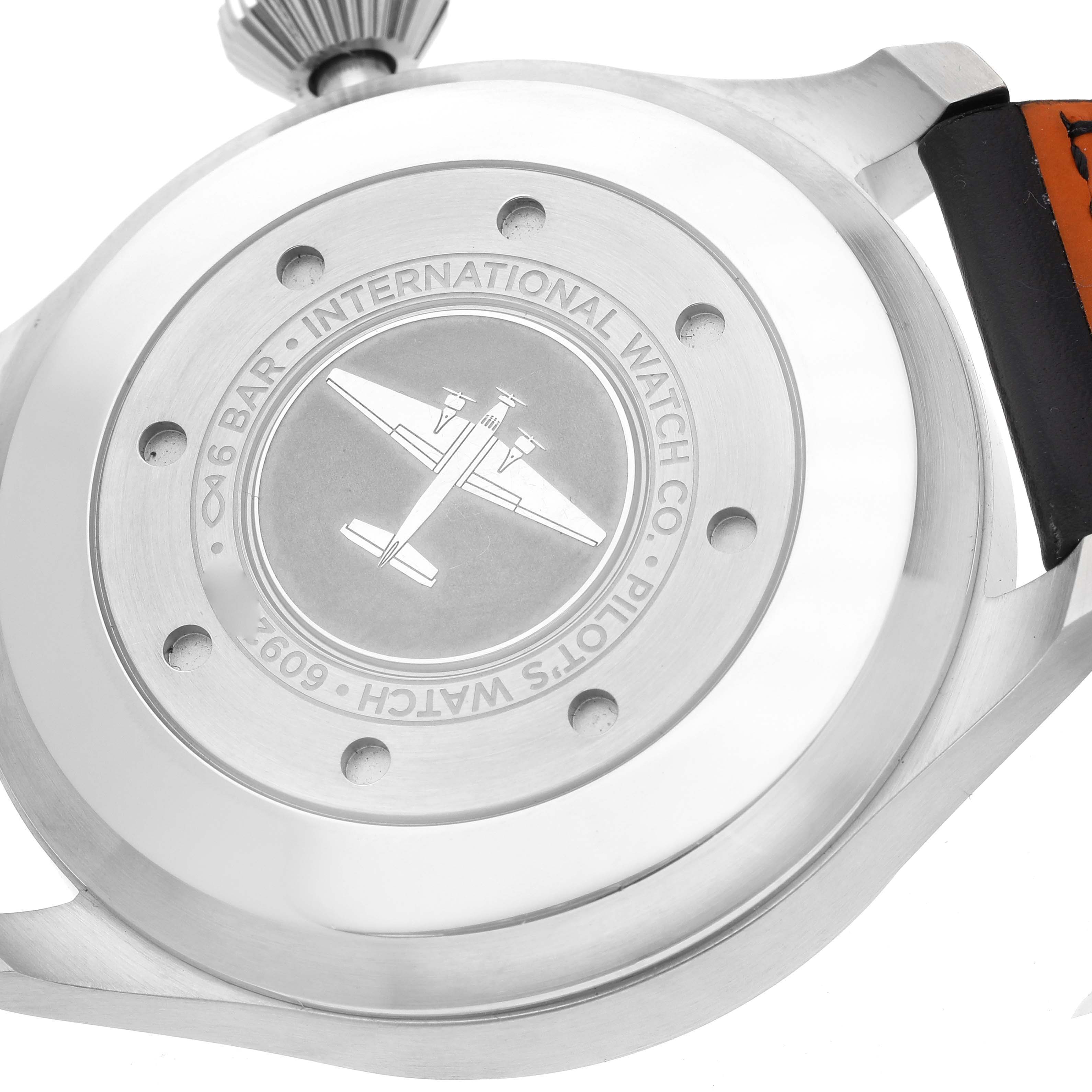 The image shows the case back of an IWC Pilot IW500912 Men's Stainless Steel Black Dial IW500912 Men's Stainless Steel Black Dial model watch, highlighting the engraved plane design and surrounding text.