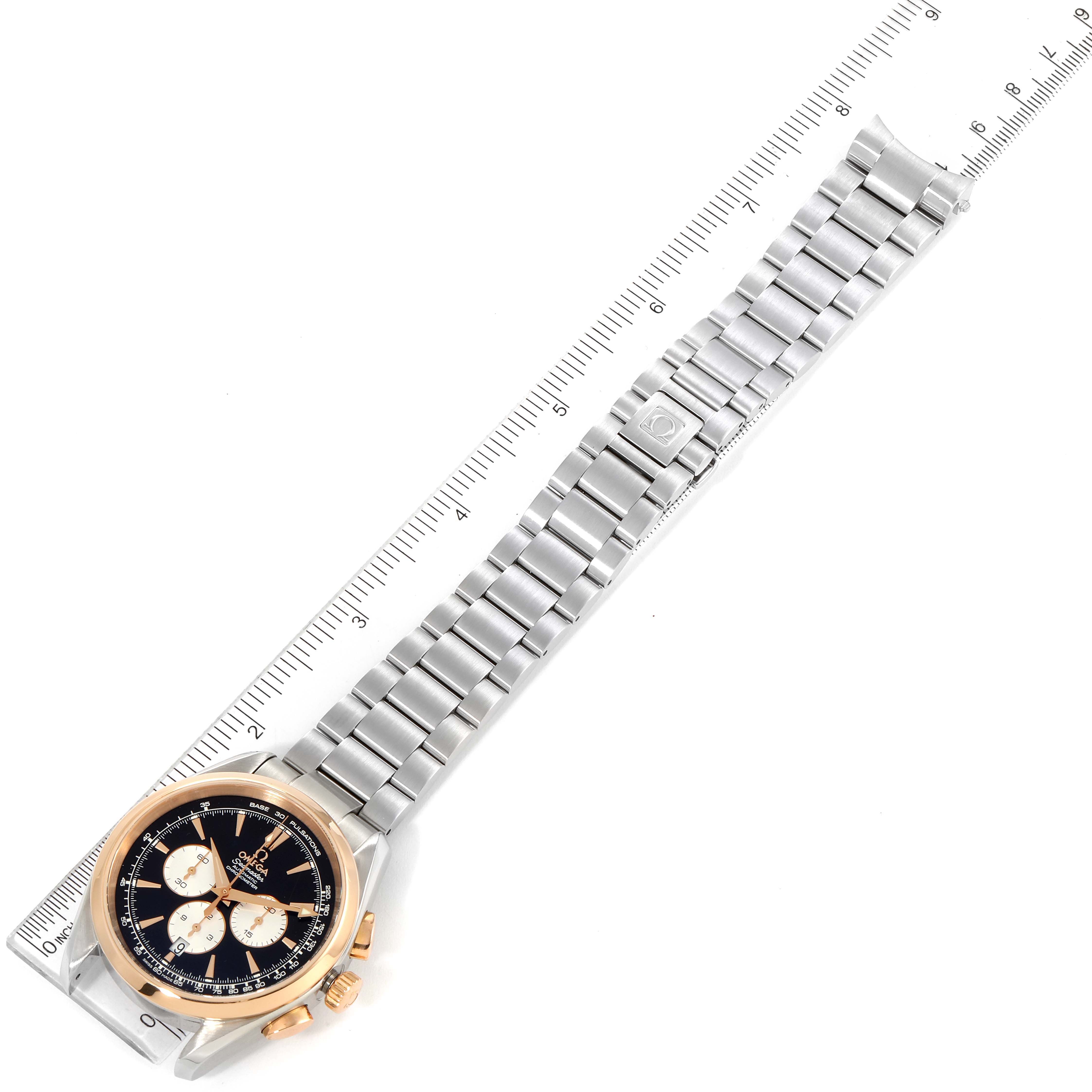 The image shows an Omega Aqua Terra 221.20.42.40.01.002 Men's Steel and Gold (two tone) Black Dial 221.20.42.40.01.002 Men's Steel and Gold (two tone) Black Dial watch lying flat with its full metal bracelet and a ruler beside it for scale.
