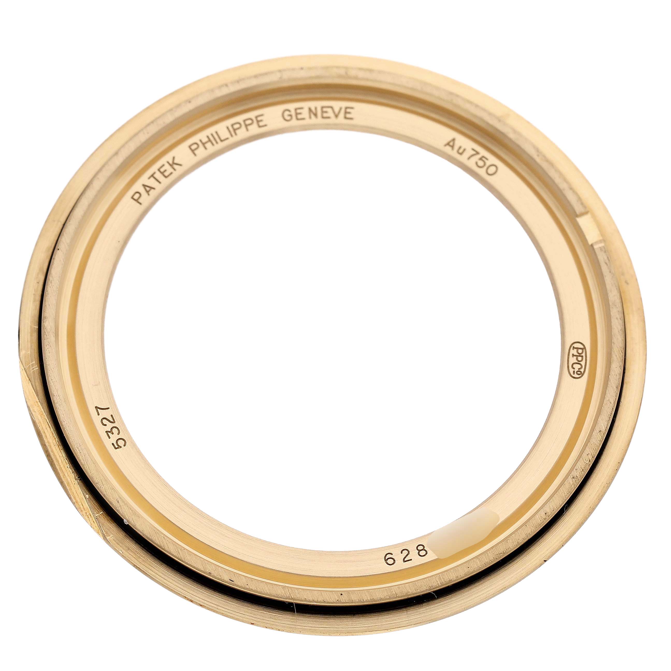 The image shows a Patek Philippe Complications 5327J-001 Men's Yellow Gold Beige Dial model bezel, photographed from above, highlighting engravings and markings.