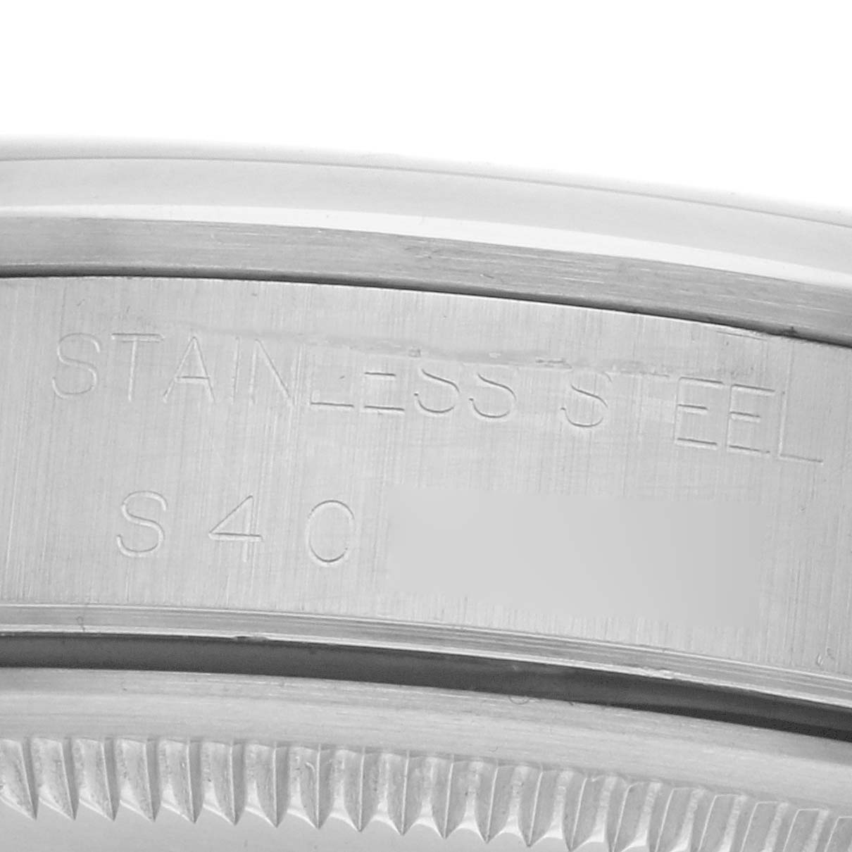 The image shows a close-up of the case side of a Rolex Air-King 14000 Men
s Stainless Steel Blue Dial watch, highlighting "STAINLESS STEEL" engraving.