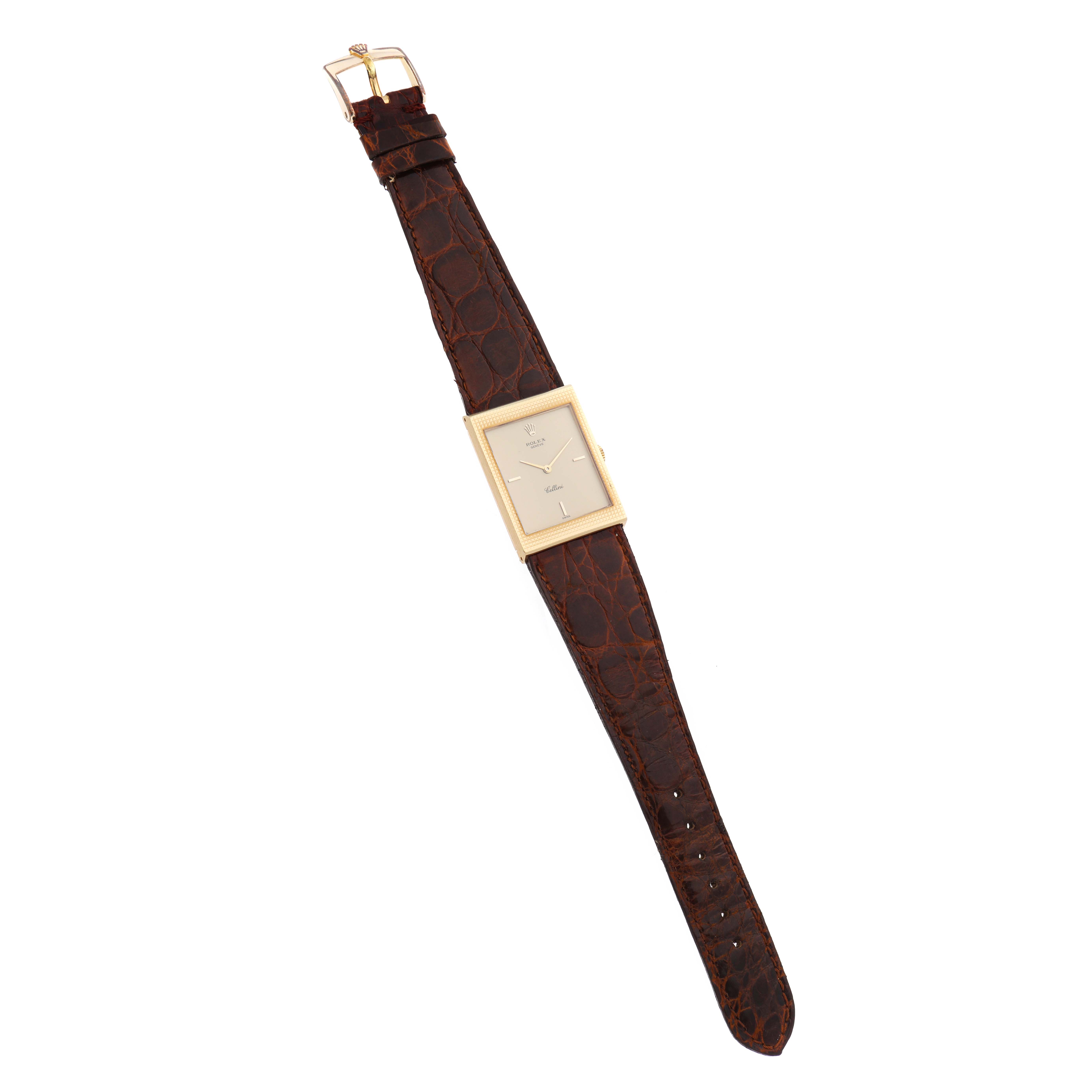 The Rolex Cellini 4127 Men
s Yellow Gold Champagne Dial watch is shown from a top view, displaying its rectangular face and brown leather strap.