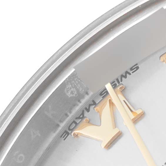 This close-up of a Rolex Datejust 279173 Women's Steel and Gold (two tone) Silver Dial 279173 Women's Steel and Gold (two tone) Silver Dial shows part of the dial, a golden Roman numeral "V," and the "Swiss Made" text.