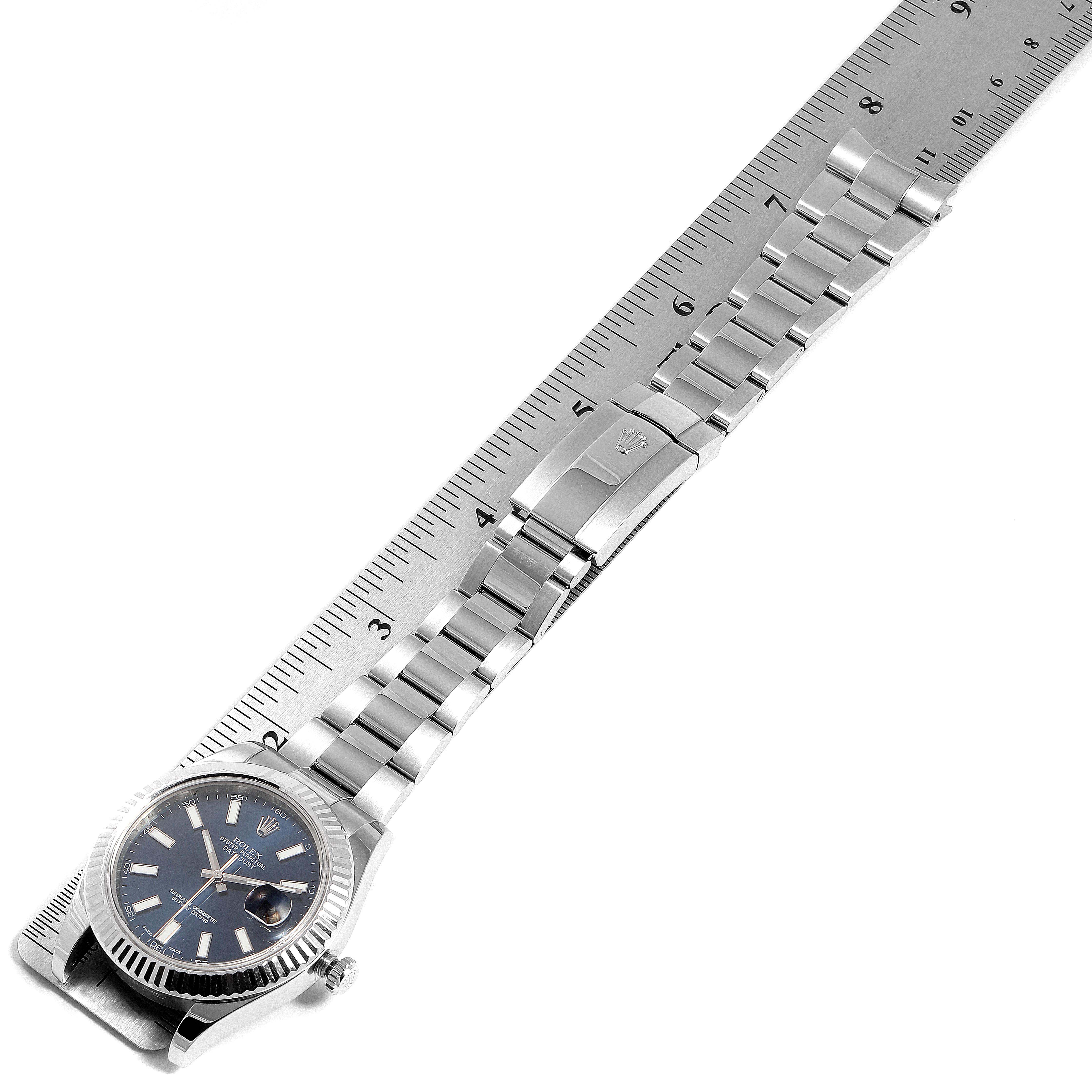 The image shows a Rolex Datejust 41 116334 Men
s Stainless Steel Blue Dial 116334 Men
s Stainless Steel Blue Dial watch laid flat with its bracelet and clasp visible, positioned alongside a ruler.