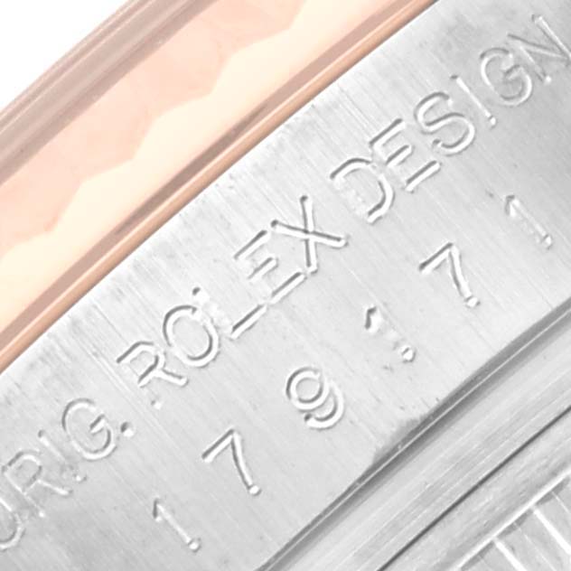 This image shows an angled close-up of the engraved serial number and "Rolex Design" on the side of a Rolex Datejust 179171 Women's Steel and Gold (two tone) White Dial 179171 Women's Steel and Gold (two tone) White Dial watch case.