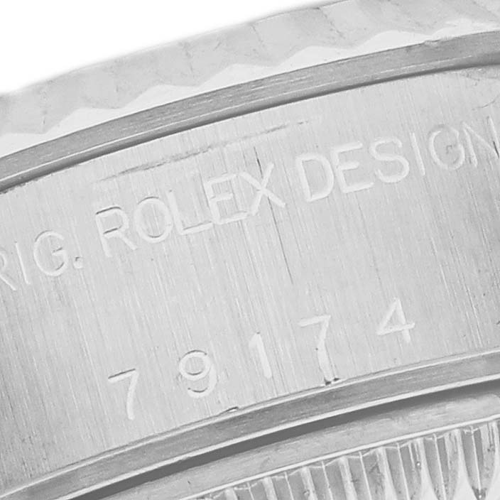 This image shows a close-up of the bezel and case of the Rolex Datejust 79174 Women's Stainless Steel Silver Dial 79174 Women's Stainless Steel Silver Dial watch, highlighting the engraved serial and model numbers.