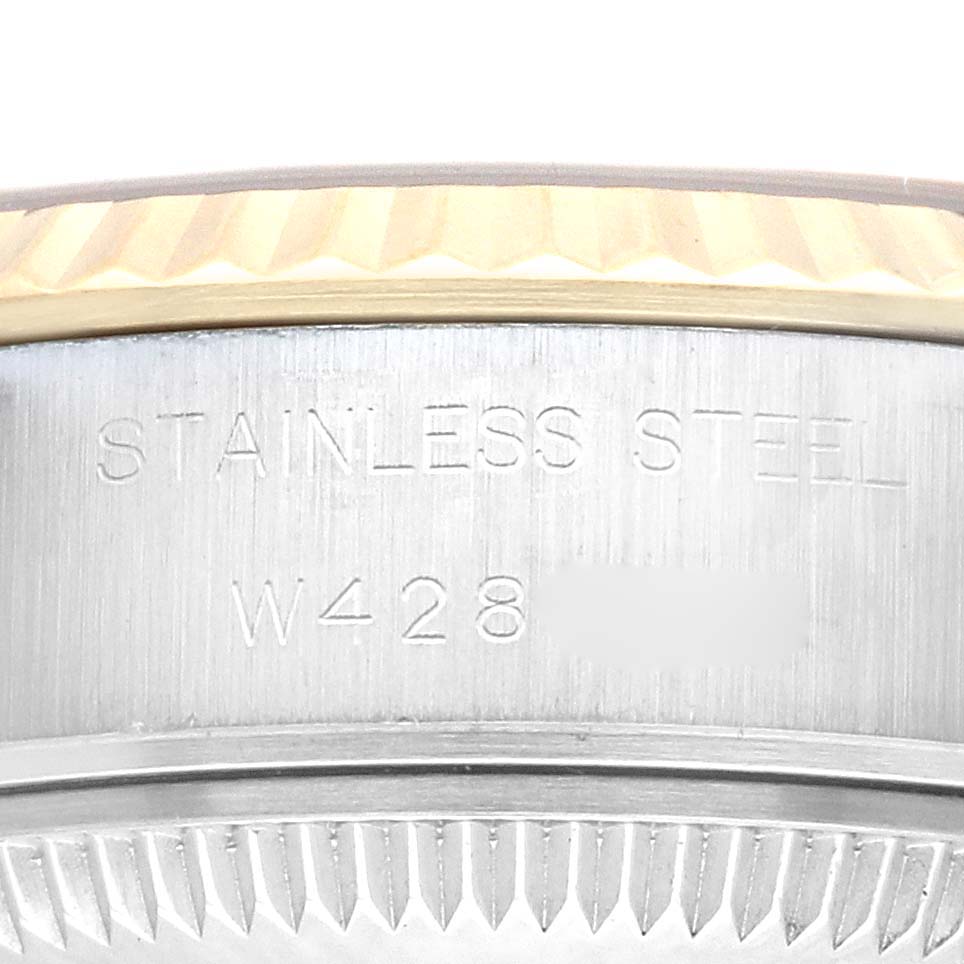 This image shows a close-up of the side of a Rolex Datejust 69173 Women's Steel and Gold (two tone) Champagne Dial 69173 Women's Steel and Gold (two tone) Champagne Dial watch, highlighting the "STAINLESS STEEL" engraving and part of the fluted bezel.