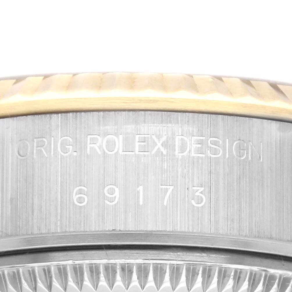 The image shows the side of a Rolex Datejust 69173 Women's Steel and Gold (two tone) Champagne Dial 69173 Women's Steel and Gold (two tone) Champagne Dial watch with the model number and "ORIG. ROLEX DESIGN" engraved.