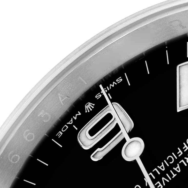 The image shows a close-up of the dial and bezel of a Rolex Explorer 124270 Men
s Stainless Steel Black Dial watch, featuring the number 9 and partial indices.