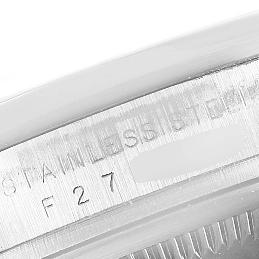 This image shows a close-up of the Rolex Explorer 114270 Men's Stainless Steel Black Dial 114270 Men's Stainless Steel Black Dial's case, featuring the engraved serial number and "STAINLESS STEEL" marking.